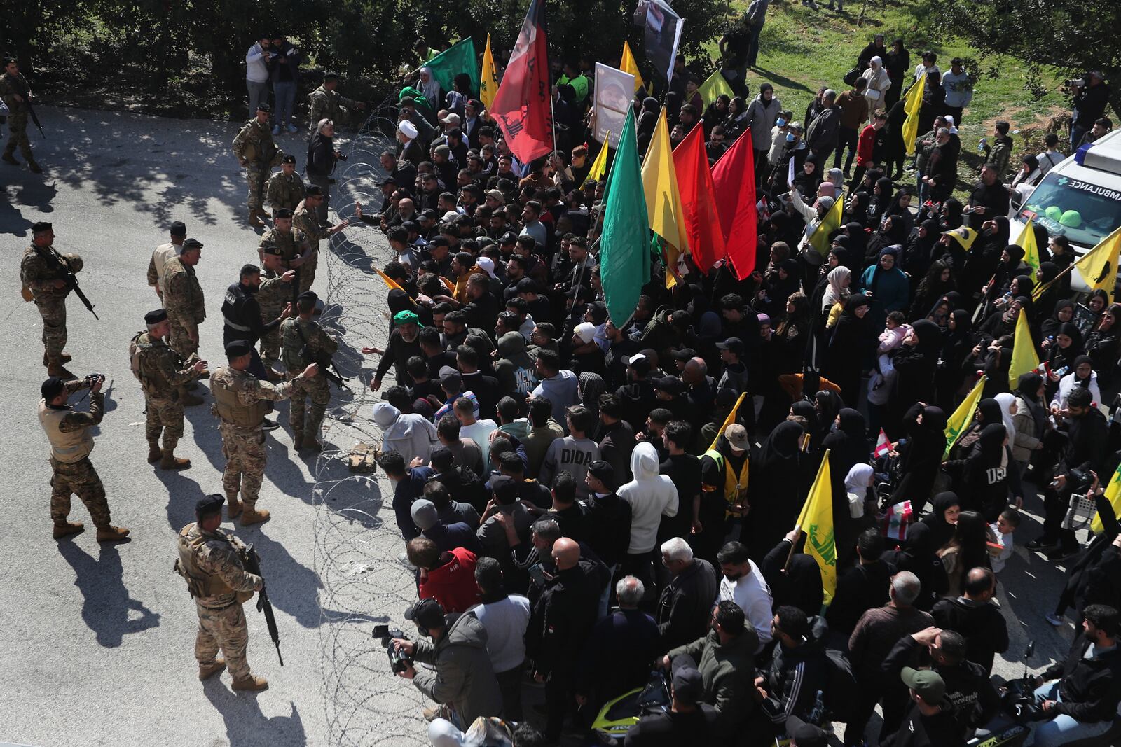 Lebanese citizens gather in front of Lebanese soldiers as they prepare to return to their villages while Israeli soldiers block a road leading to the southern Lebanese village of Kfar Kila, Lebanon, Sunday, Feb. 2, 2025. (AP Photo/Mohammed Zaatari)