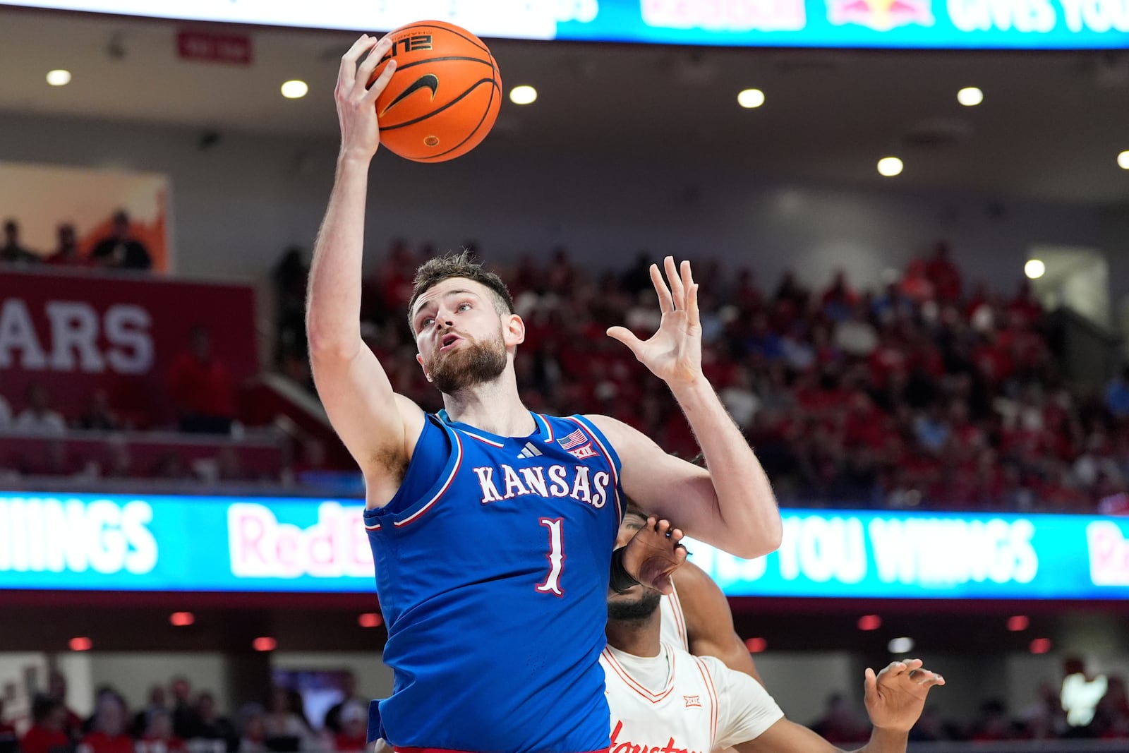 Kansas's Hunter Dickinson (1) goes up for a shot as Houston's Ja'Vier Francis defends during the first half of an NCAA college basketball game Monday, March 3, 2025, in Houston. (AP Photo/David J. Phillip)