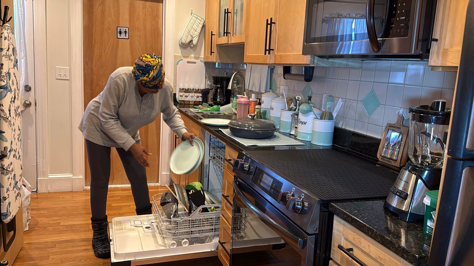 Julieta Lopez unloads the dishwasher, the first she has ever owned, in her condo in Boston, Friday, Jan. 10, 2025, two years after she bought her first home, capping a 30-year pursuit of homeownership. (AP Photo/Rodrique Ngowi)