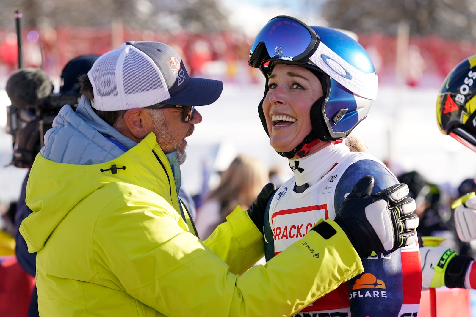 United States' Lindsey Vonn, right, is congratulated by Red Bull Head of Athletes Special Projects Patrick Riml after she competed in an alpine ski, women's World Cup super G, in St. Moritz, Switzerland, Saturday, Dec. 21, 2024. (AP Photo/Giovanni Auletta)