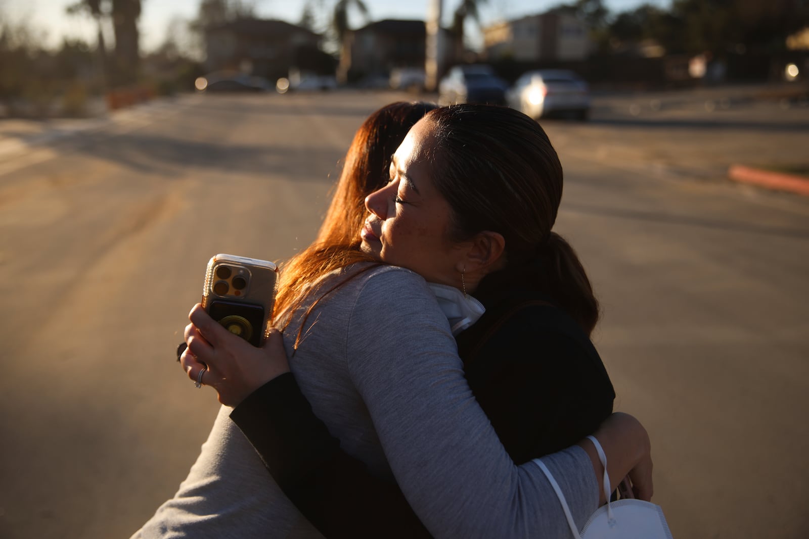 Pasadena Park Healthcare & Wellness Center COO Amy Johnson, left, hugs Rhea Bartolome, vice president of operations, outside their center after the Eaton Fire, Sunday, Jan. 12, 2025, in Pasadena, Calif. They returned to check on the facility after evacuating senior care residents from the fire. (AP Photo/Ethan Swope)