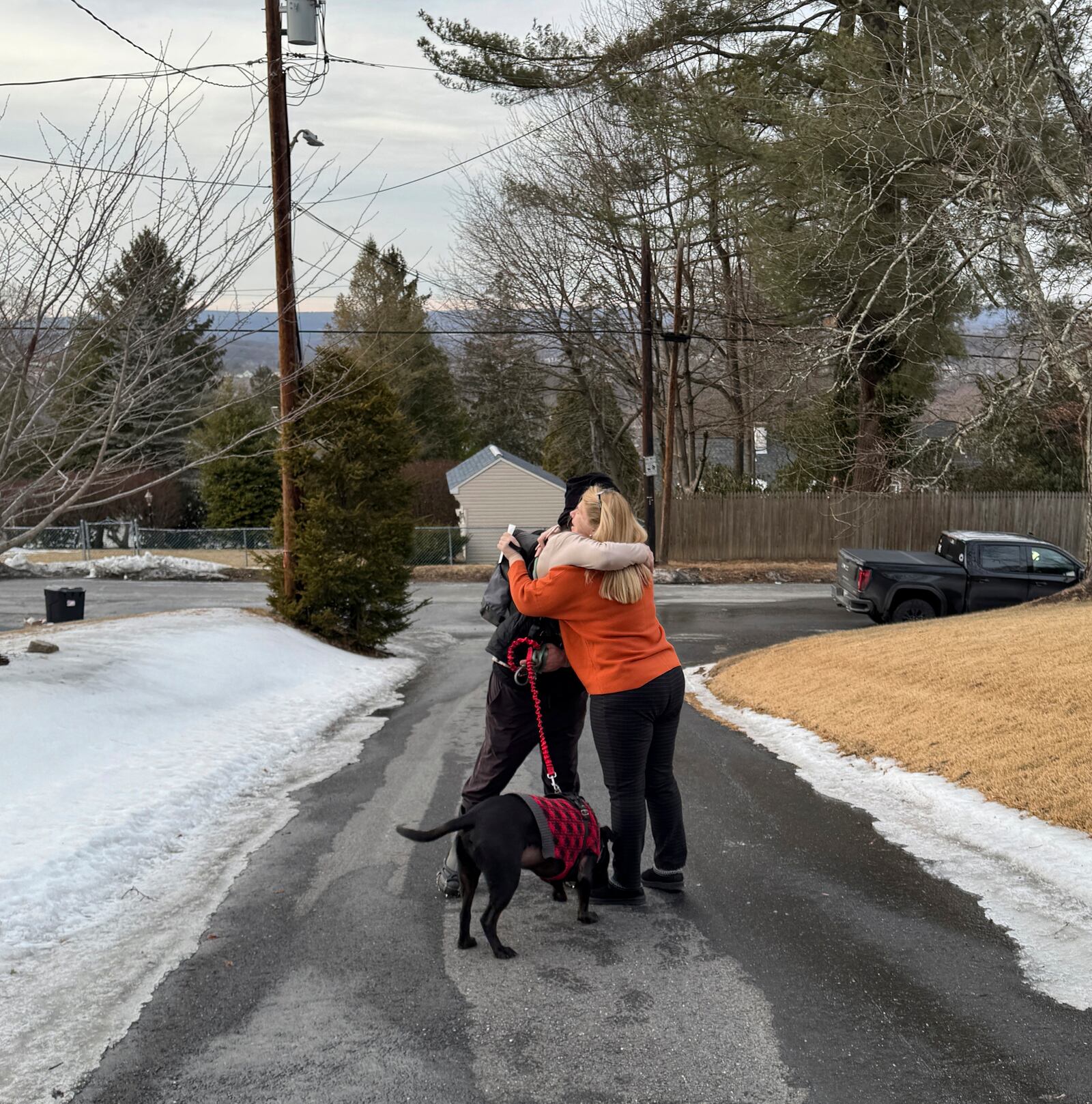 In this Feb. 24, 2025 photo provided by Dr, Carolyn Canizaro-Orlowsky, shown Pam Palko, right, embracing hiker Collin Leiby, with his dog Bass, after he found her missing six-month-old Golden retriever pup named Freddy, who a week after the dog ran off from Palko's home at the base of Sharp Mountain in Pottsville, Pa. (Dr, Carolyn Canizaro-Orlowsky via AP)