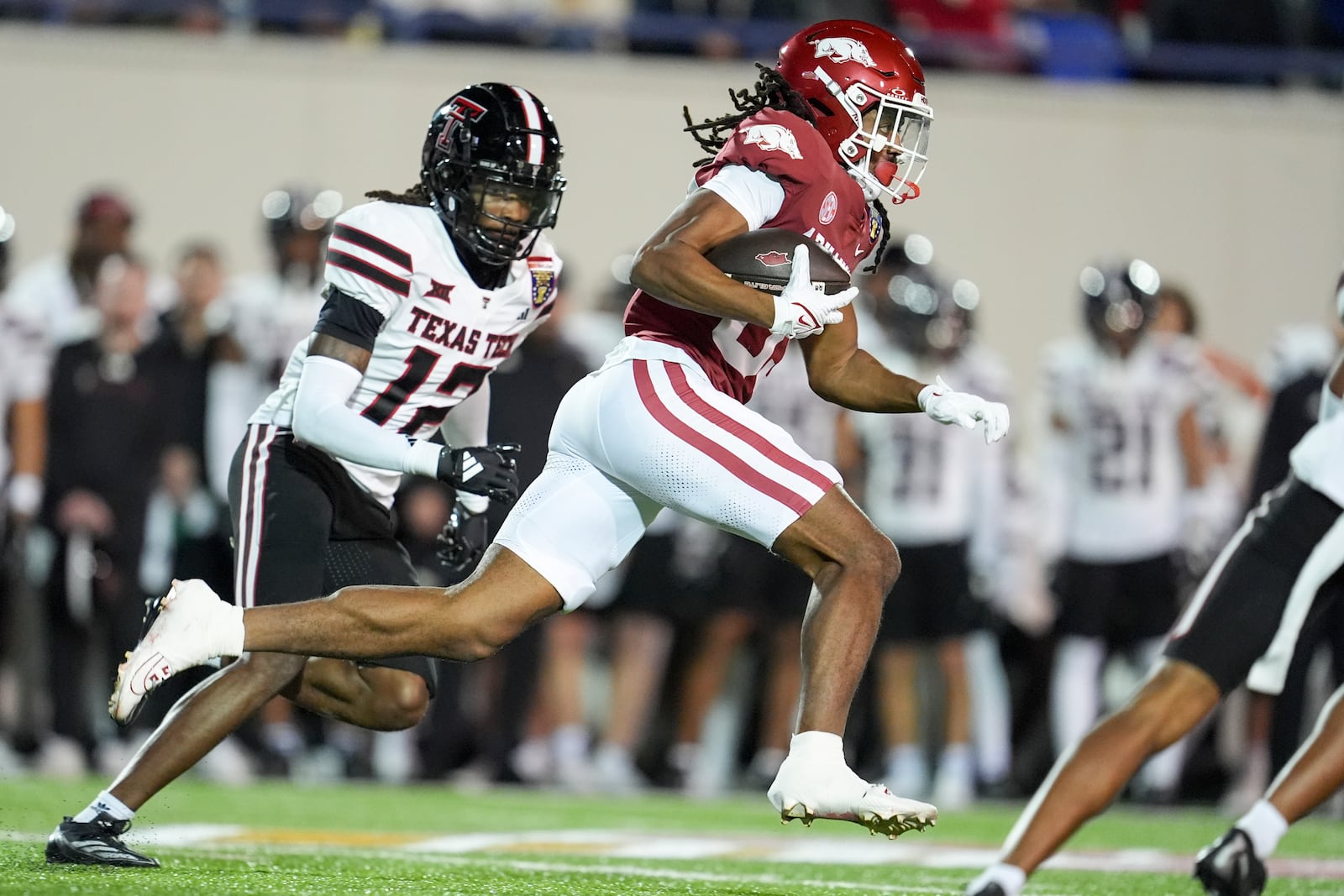 Arkansas wide receiver Dazmin James (83) runs past Texas Tech defensive back Macho Stevenson (12) to score a touchdown during the first half of the Liberty Bowl NCAA college football game Friday, Dec. 27, 2024, in Memphis, Tenn. (AP Photo/George Walker IV)