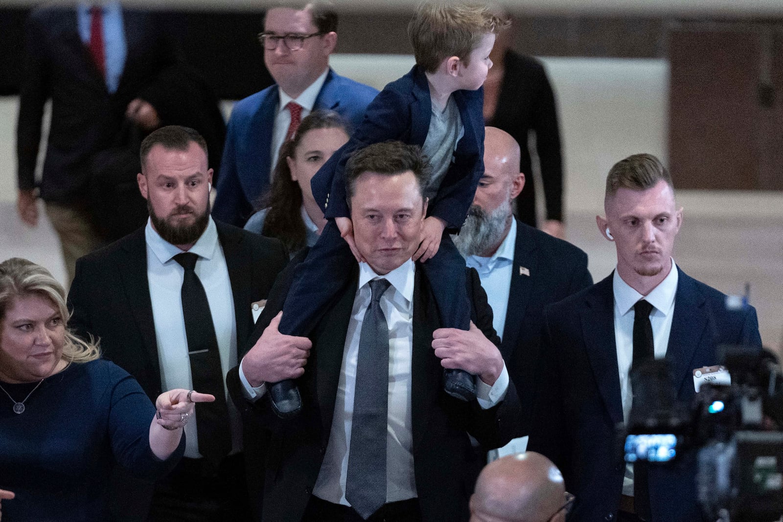 Elon Musk, carrying his son X Æ A-Xii, leaves after a meeting with members of congress to discuss President-elect Donald Trump's planned Department of Government Efficiency on Capitol Hill in Washington, Thursday, Dec. 5, 2024. (AP Photo/Jose Luis Magana)