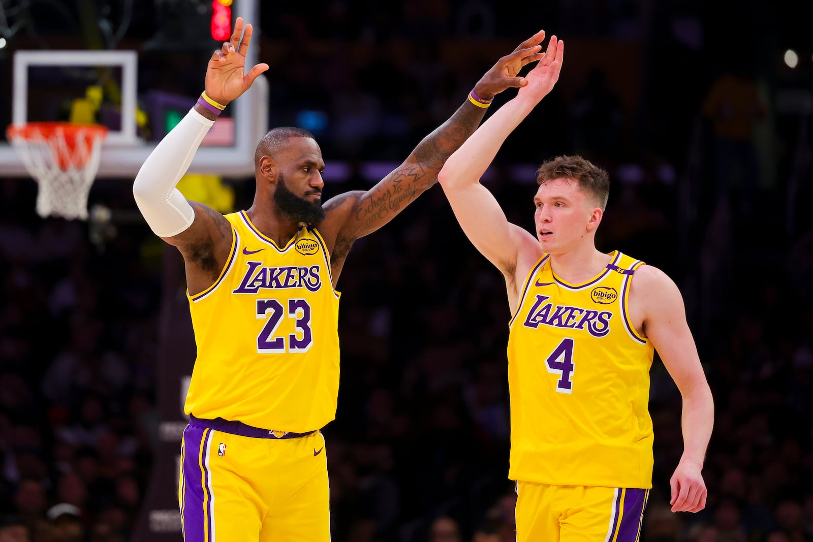 Los Angeles Lakers forward LeBron James (23) high-fives guard Dalton Knecht (4) during the first half of an NBA basketball game against the Cleveland Cavaliers, Tuesday, Dec. 31, 2024, in Los Angeles. (AP Photo/Ryan Sun)