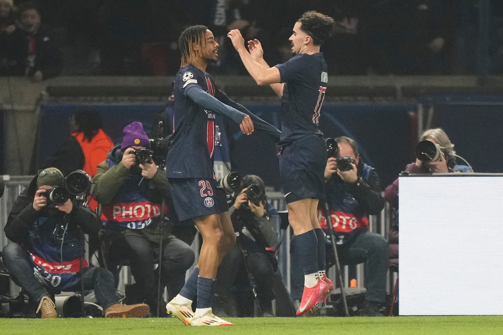 PSG's Bradley Barcola, left, celebrates with a teammate after scoring the opening goal of his team against Brest during the Champions League playoff second leg soccer match between Paris Saint-Germain and Brest at the Parc des Princes in Paris, Wednesday, Feb. 19, 2025. (AP Photo/Michel Euler)