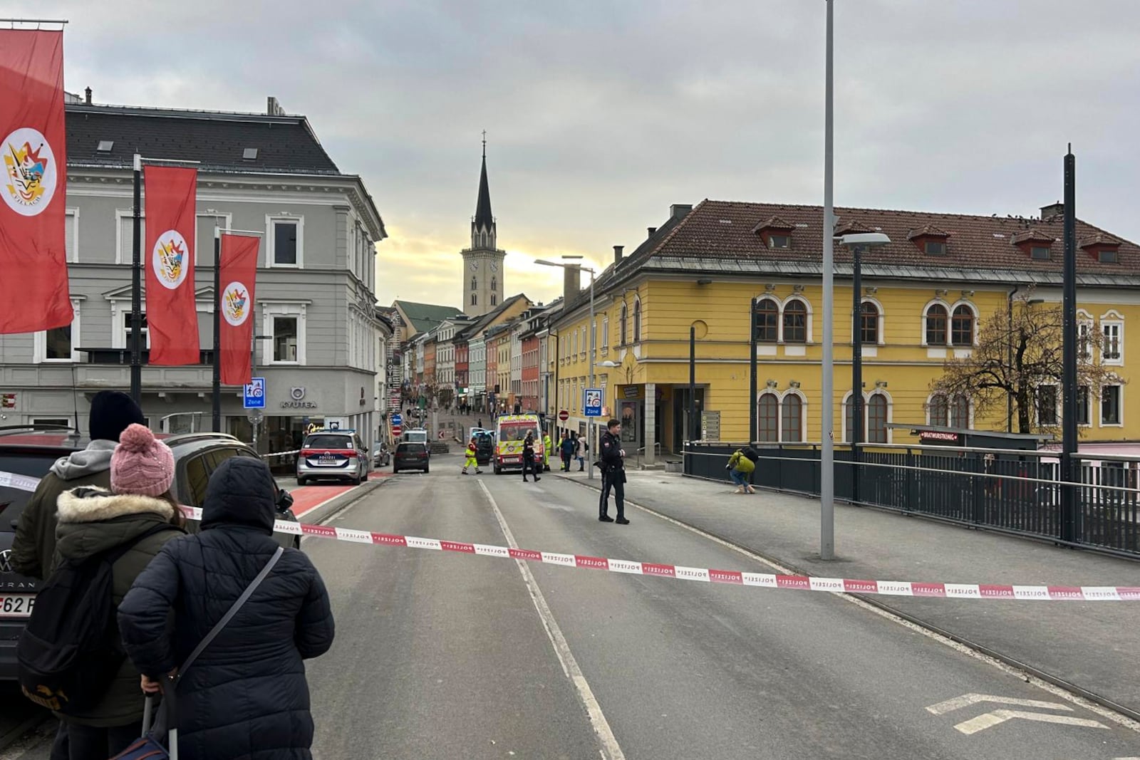 People look into a cordoned off area where a 23-year-old man stabbed several people in the southern Austria city of Villach, Saturday, Feb. 15, 2025. (Wiesflecker/Kleine Zeitung via AP)