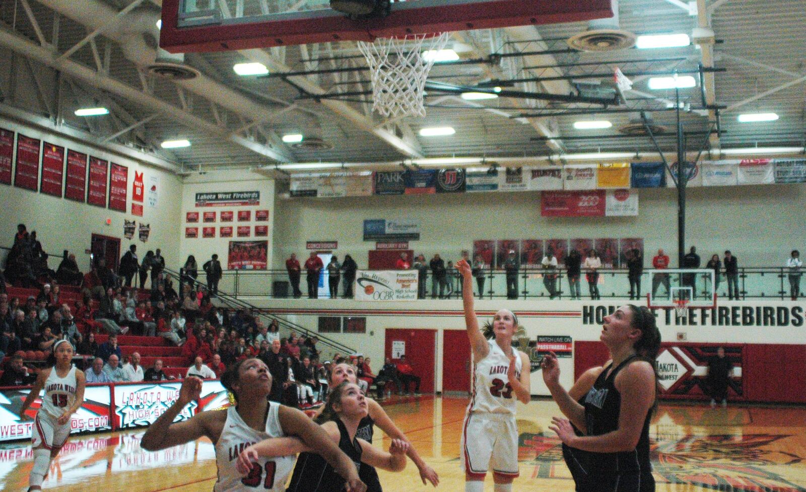 Lakota West’s Kailyn Dudukovich (23) puts up a shot in the lane as teammate Nevaeh Dean (31) fights for rebounding position during Saturday night’s Journey to the Tourney contest at West. The host Firebirds won 61-53. RICK CASSANO/STAFF