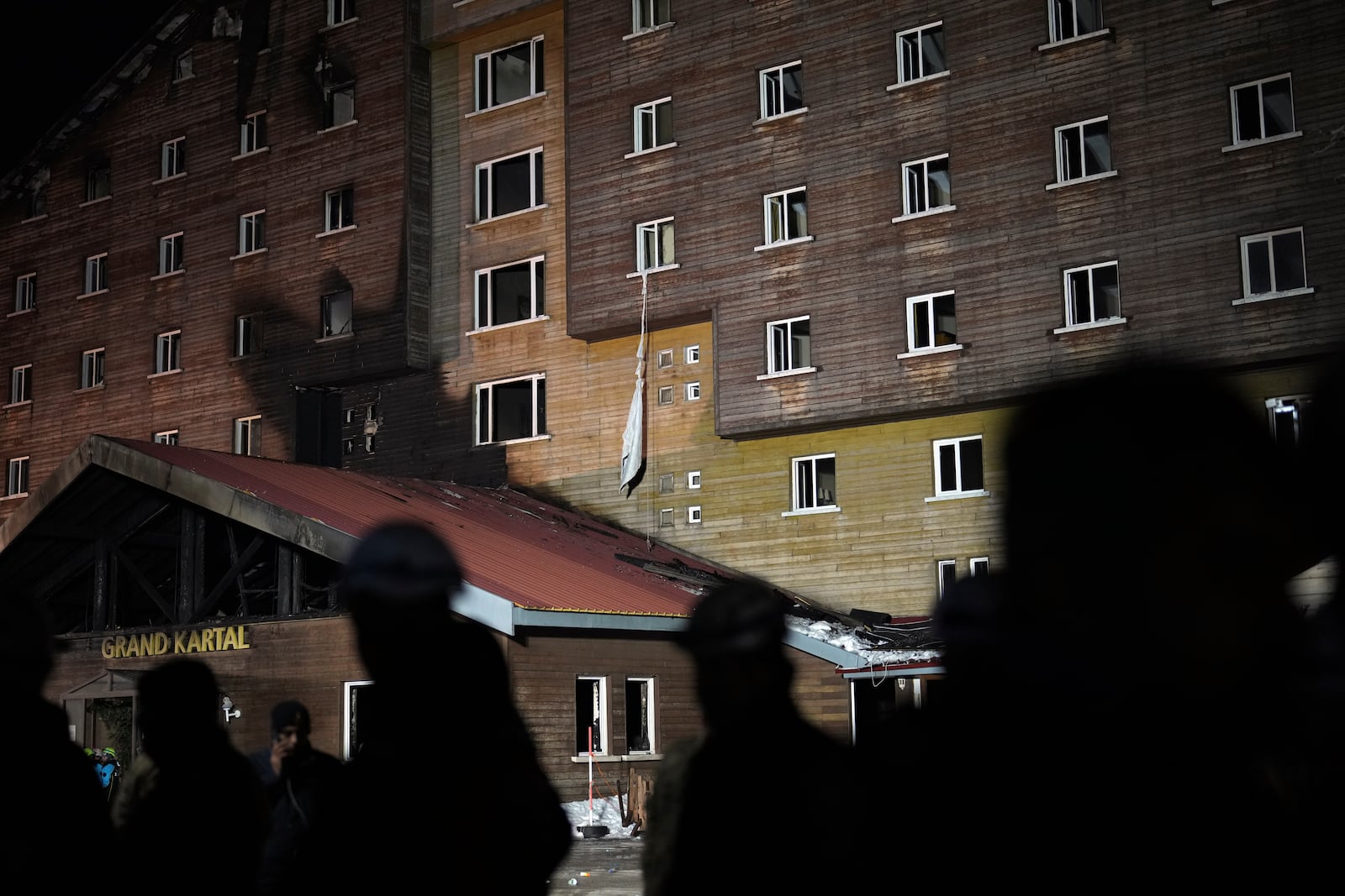 Tightened bed sheets hang from a window of a hotel where a fire broke out at the Kartalkaya ski resort in Bolu province, northwest Turkey, Tuesday, Jan. 21, 2025. (AP Photo/Francisco Seco)