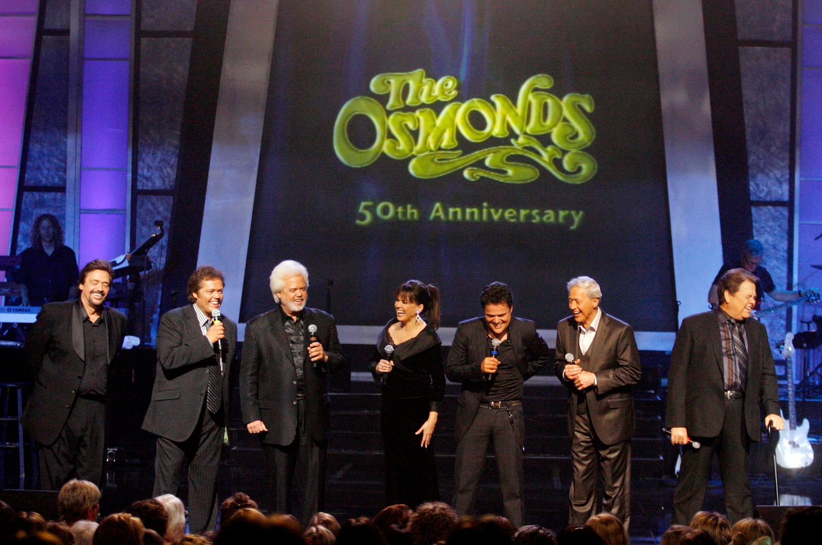 FILE - The Osmonds from left, Jay, Jimmy, Merrill, Marie, Donny, Wayne, and Alan perform during a taping of their 50th anniversary show at the Orlean's casino in Las Vegas, Tuesday, Aug. 14, 2007. (AP Photo/Isaac Brekken, File)