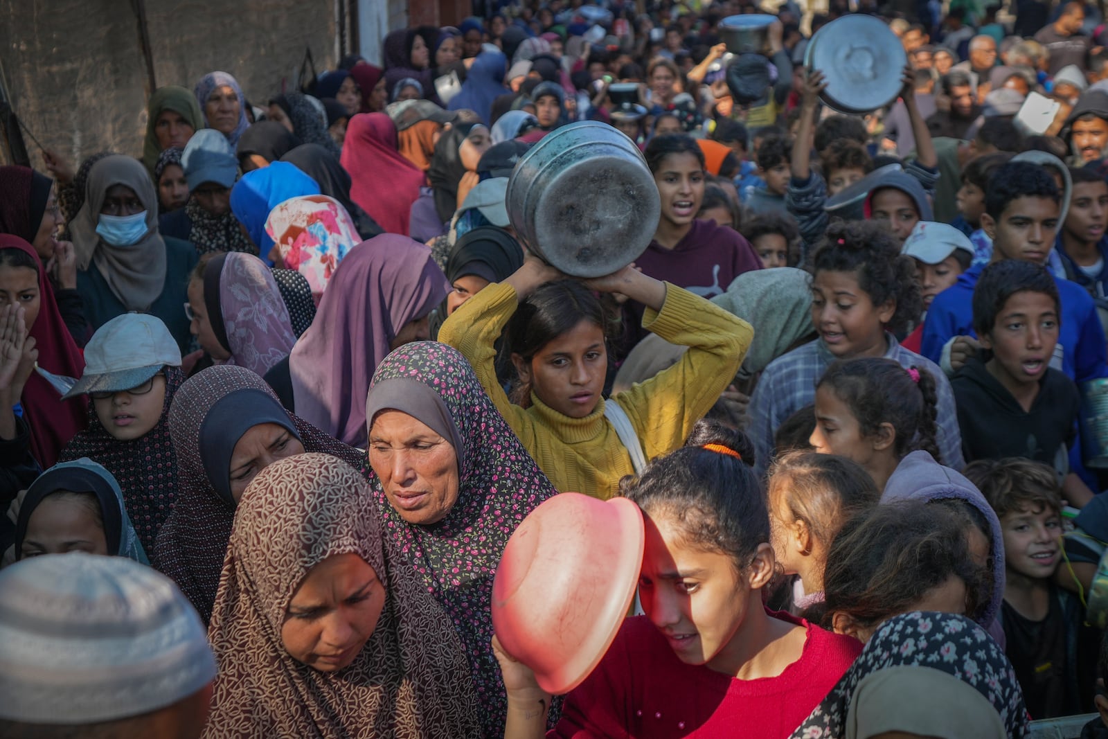 Palestinian children queue for donated food in Deir al-Balah, Gaza Strip, Friday Nov. 22, 2024. (AP Photo/Abdel Kareem Hana)