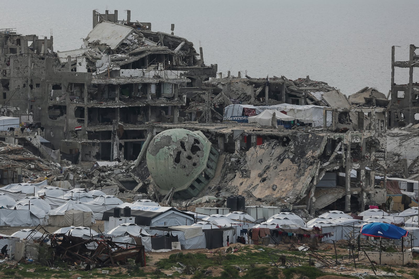 A tent camp for displaced Palestinians is set up amid destroyed buildings in the west of Al-Shati camp, west of Gaza City, on Monday, March 3, 2025. (AP Photo/Jehad Alshrafi)