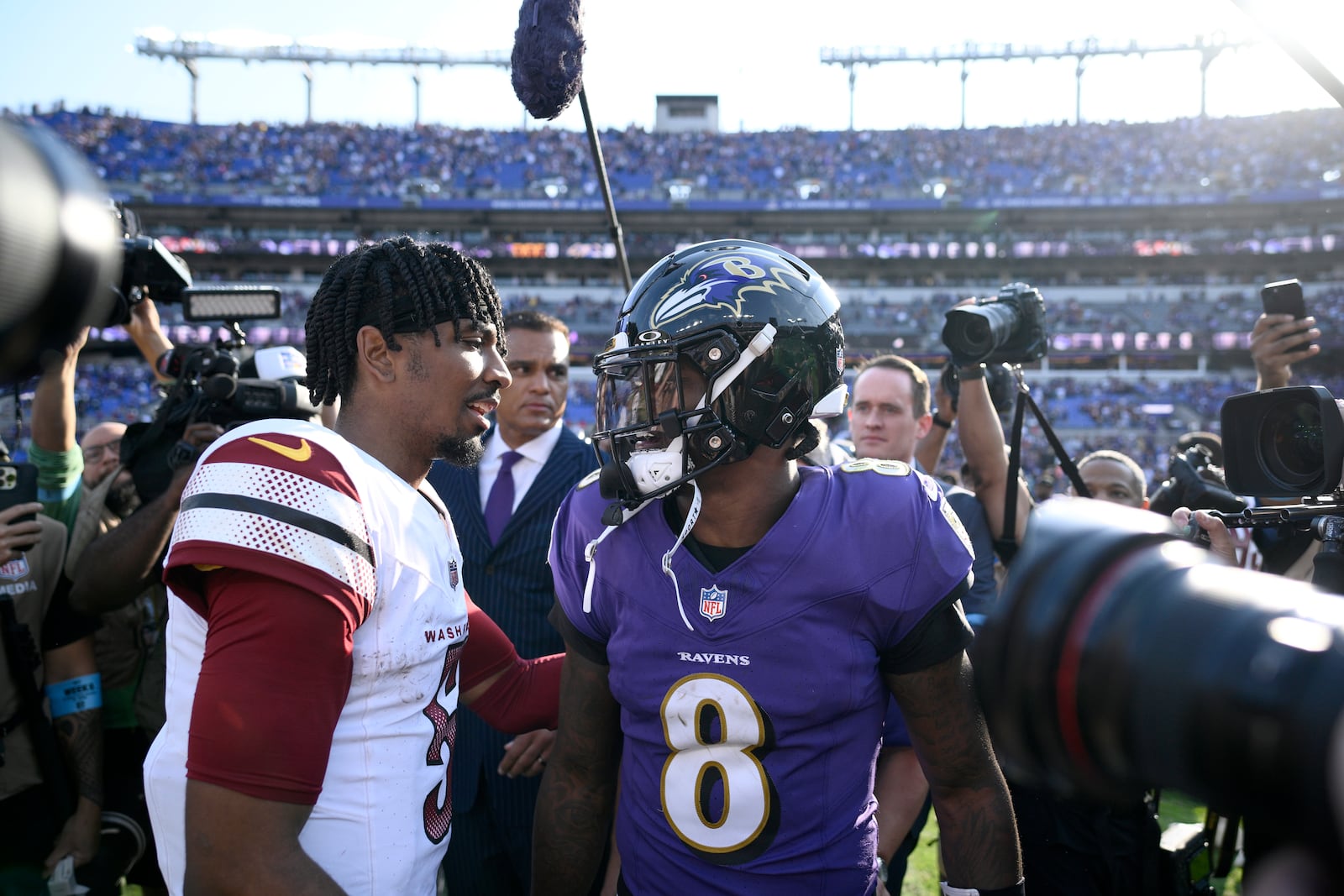 Washington Commanders quarterback Jayden Daniels, left, talks with Baltimore Ravens quarterback Lamar Jackson following an NFL football game Sunday, Oct. 13, 2024, in Baltimore. The Ravens won 30-23. (AP Photo/Nick Wass)