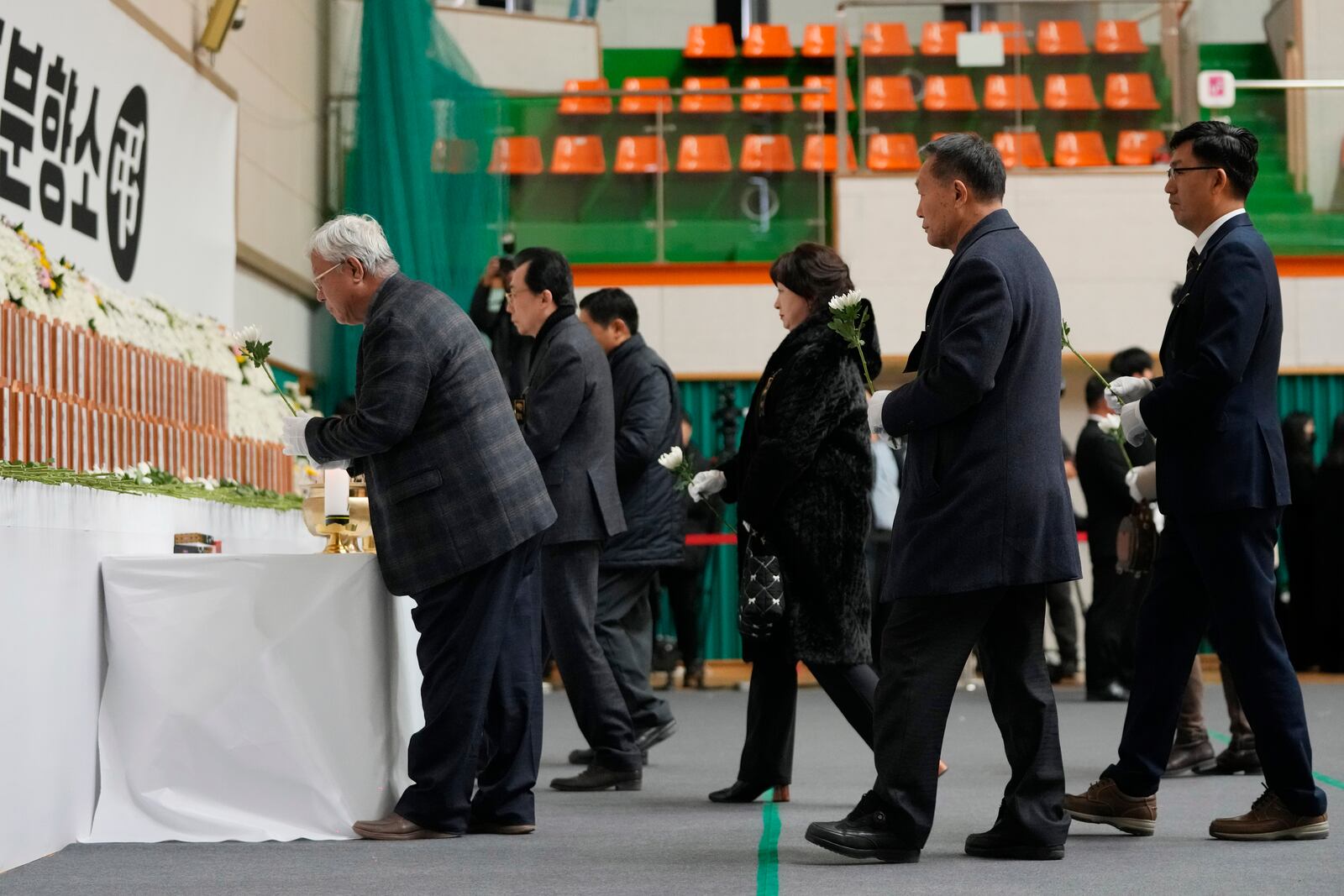 Mourners place flowers for the victims of a plane fire at a memorial altar at Muan sport park in Muan, South Korea, Monday, Dec. 30, 2024. (AP Photo/Ahn Young-joon)