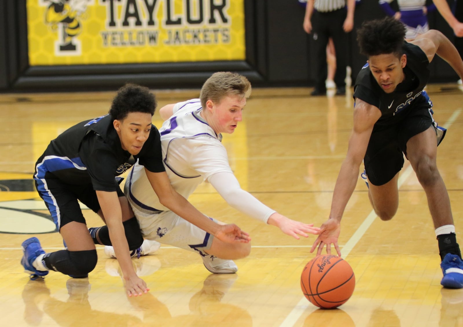 Cincinnati Christian’s Logan Woods (left) and teammate Miguel Ringer (2) battle Miami Valley Christian Academy’s Landon Croswell (5) for the ball last Saturday during a Division IV district semifinal basketball game at Taylor. CCS won 55-40. PHOTO BY KRAE/WWW.KRAEPHOTOGRAPHY.COM