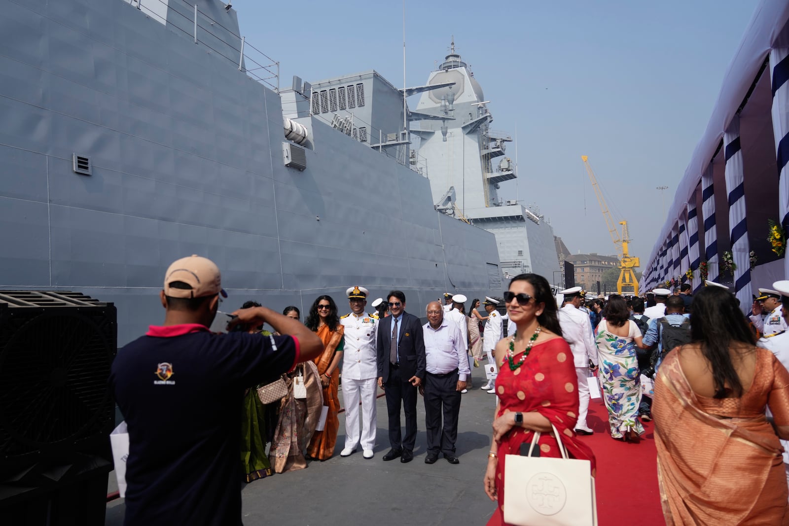 Indian naval officers takes pictures after the commissioning ceremony of a submarine, a destroyer and a frigate built at a state-run shipyard in Mumbai, India, Wednesday, Jan. 15, 2025. (AP Photo/Rafiq Maqbool)