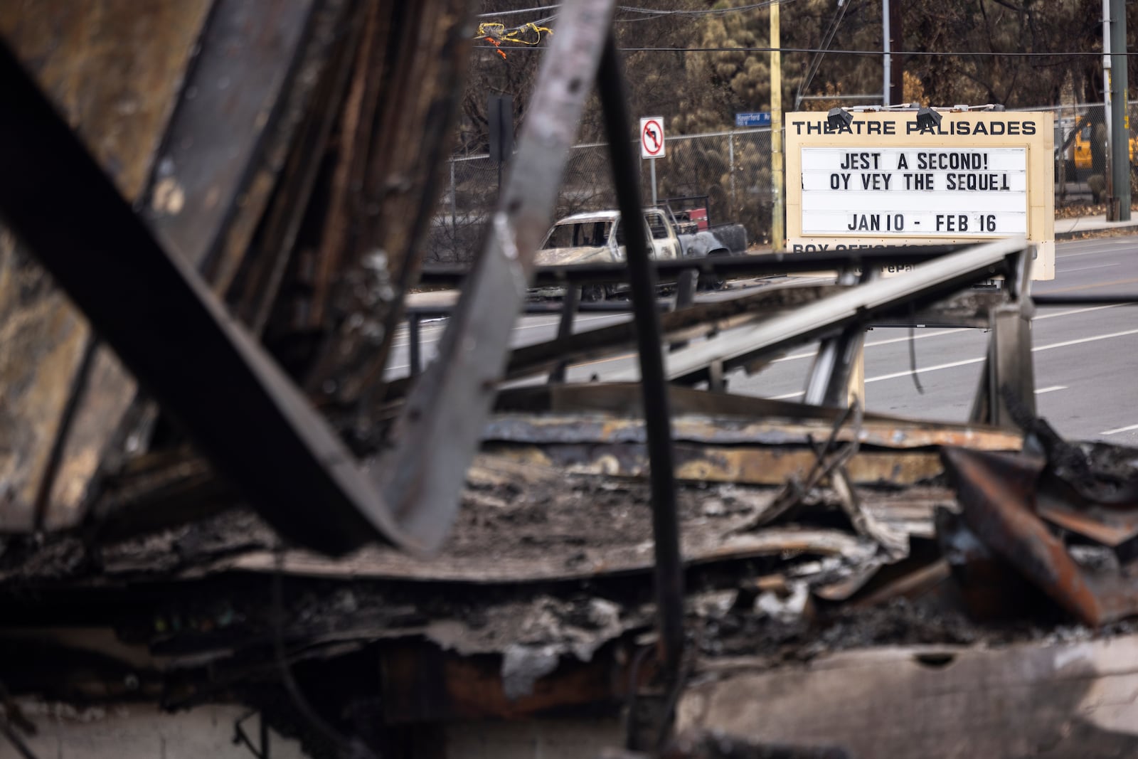 A billboard reads "Theatre Palisades" next to the theater destroyed by the Palisades Fire, in the Pacific Palisades neighborhood of Los Angeles, Calif., Saturday, Jan. 25, 2025.(AP Photo/Etienne Laurent)