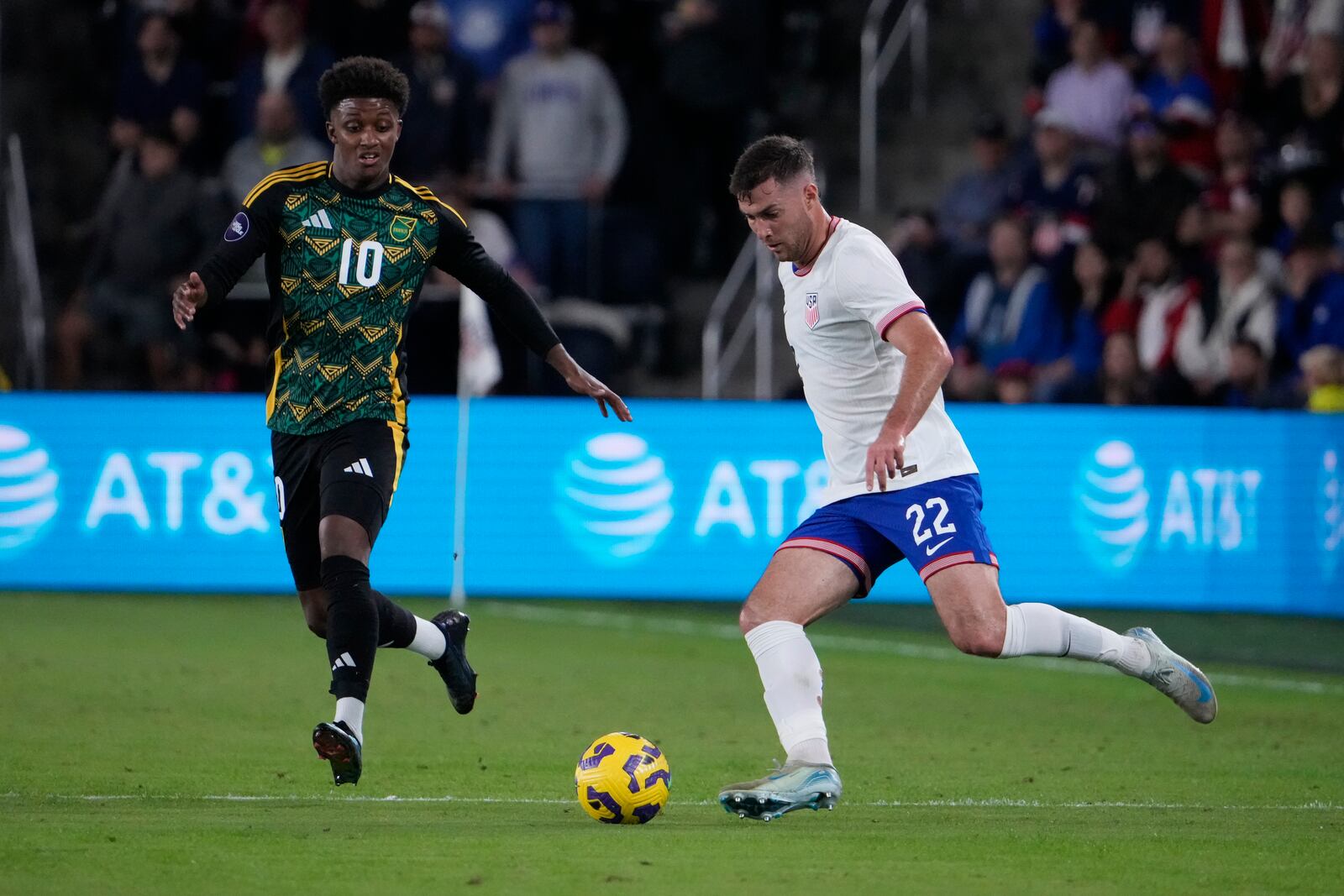 United States' Joe Scally (22) passes around Jamaica's Demarai Gray (10) during the first half in a CONCACAF Nations League quarterfinal second leg soccer match Monday, Nov. 18, 2024, in St. Louis. (AP Photo/Jeff Roberson)