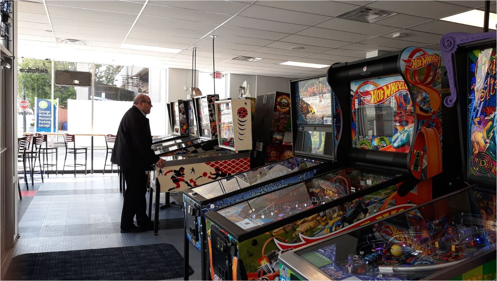 A customer at the Pinball Garage bar in Hamilton plays a game. Tokens are a quarter, and games typically cost 2-4 tokens, with tokens costing less if bought in bigger quantities. MIKE RUTLEDGE/STAFF