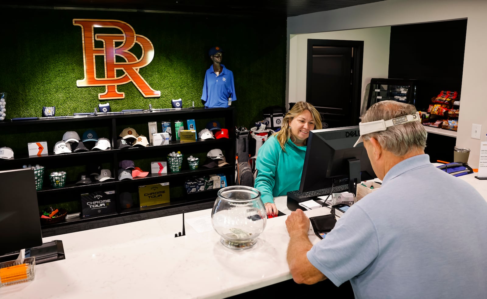 Brandy Hellard checks in golfer, Jim mMcWhorter, at the pro shop in the new Water Tower Bourbon & Beers clubhouse at Brown's Run Golf Course in Madison Township. NICK GRAHAM/STAFF