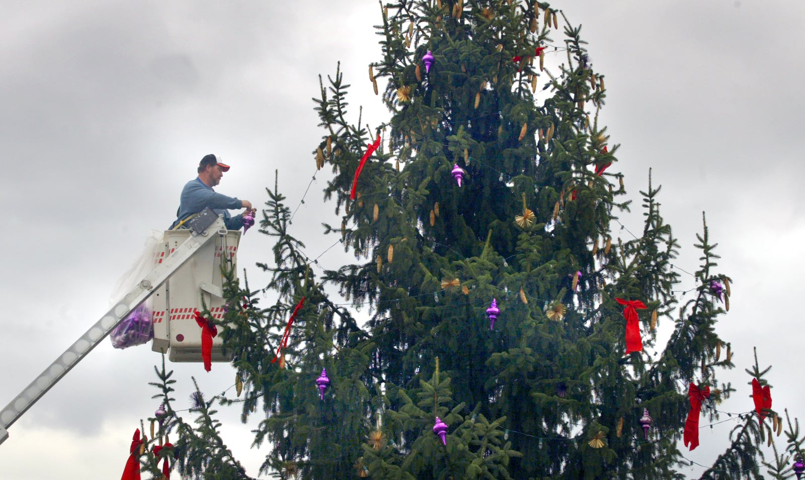 Kent Haller of the Fairborn Plant Maintenance Department decorates the holiday Christmas tree on Central Ave. STAFF PHOTO BY BILL REINKE.