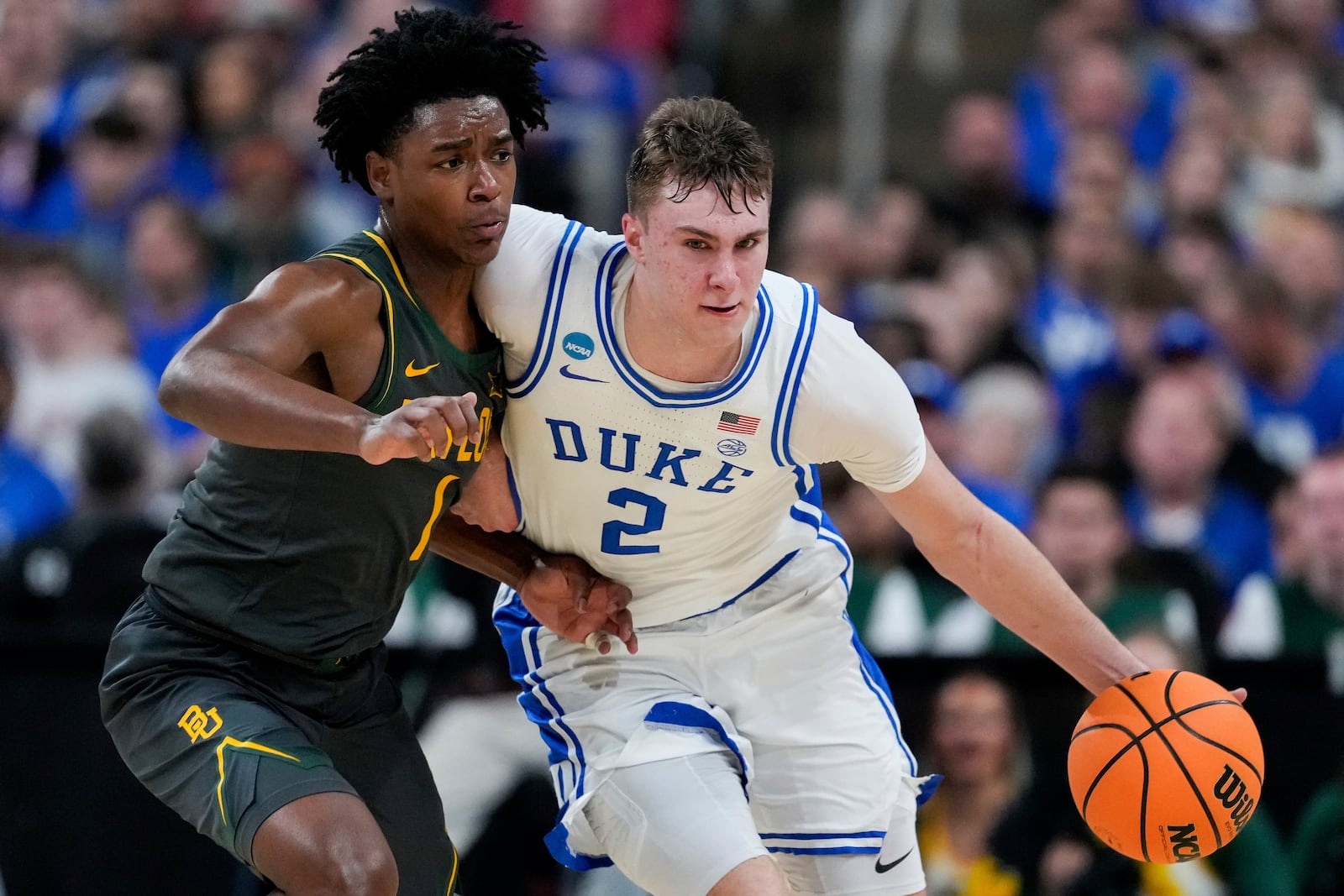 Duke forward Cooper Flagg (2) drives past Baylor guard Robert Wright III (1) during the second half in the second round of the NCAA college basketball tournament, Sunday, March 23, 2025, in Raleigh, N.C. (AP Photo/Stephanie Scarbrough)