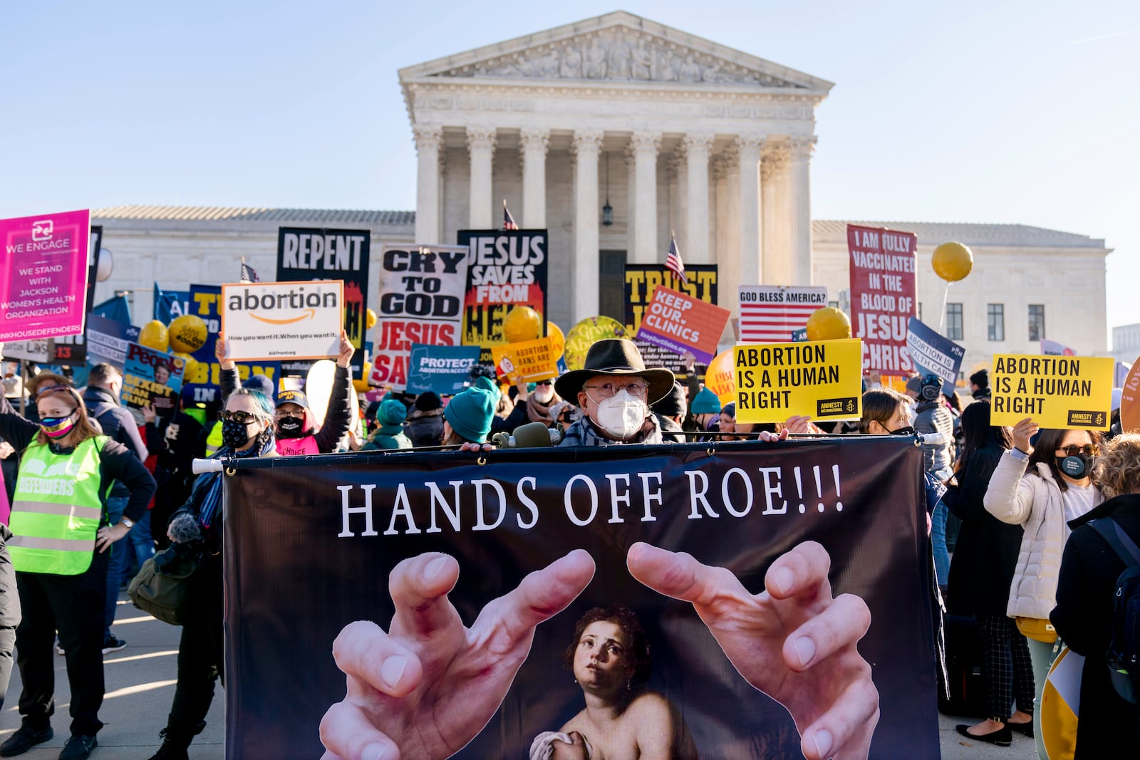 FILE - Stephen Parlato of Boulder, Colo., holds a sign that reads "Hands Off Roe!!!" as abortion rights advocates and anti-abortion protesters demonstrate in front of the U.S. Supreme Court, Wednesday, Dec. 1, 2021, in Washington. (AP Photo/Andrew Harnik, File)