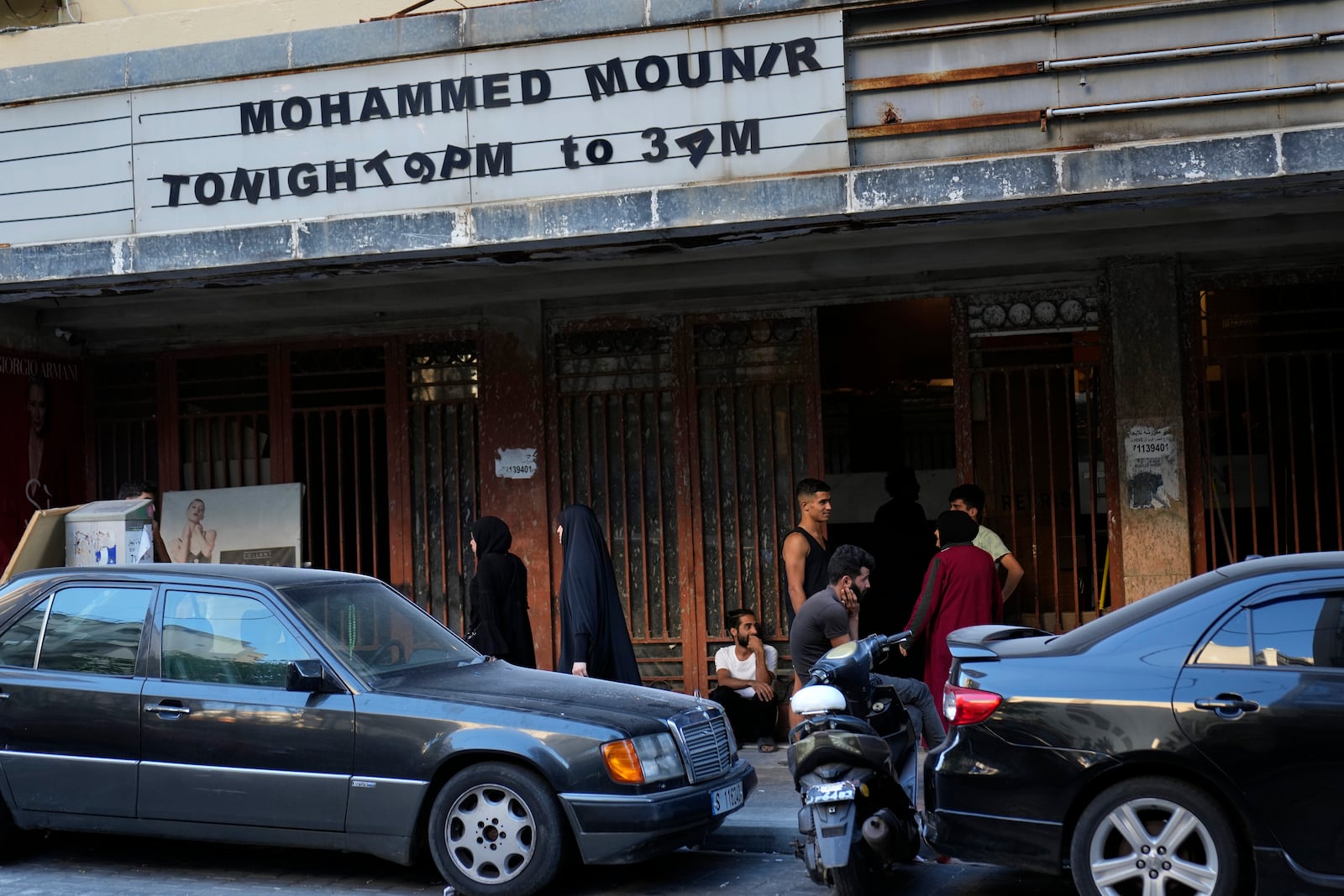 Displaced people, who fled the ongoing Hezbollah-Israel war in south Lebanon, gather at the entrance of one of Beirut's oldest and best known movie theatres, Le Colisee, where they have taken shelter in Beirut, Lebanon, Tuesday, Oct. 22, 2024. (AP Photo/Hussein Malla)