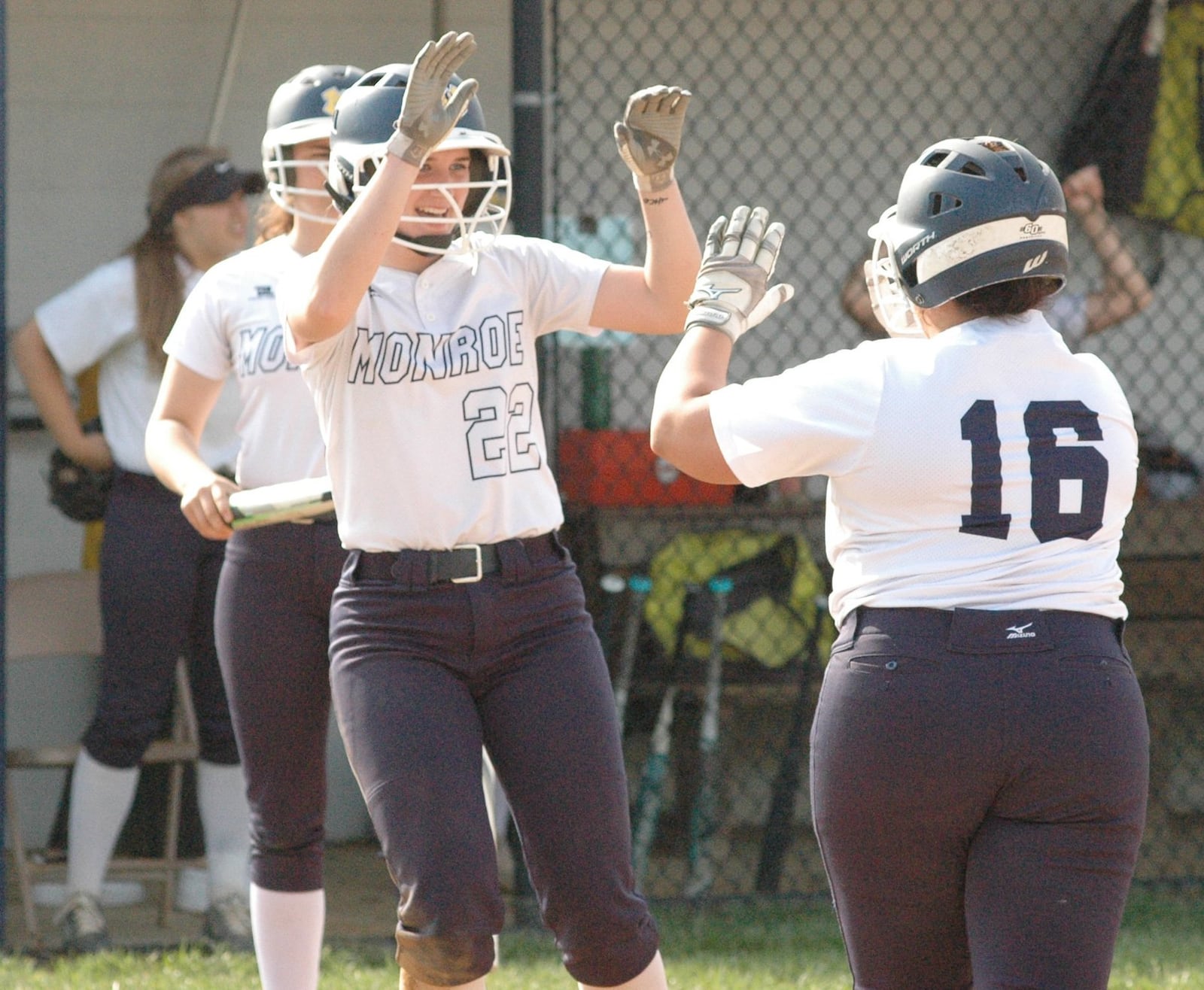 Monroe’s Sam Schwab (22) greets Makenzi Moore (16) after Moore drove in Schwab in the second inning Tuesday during a Southwestern Buckeye League Southwestern Division softball game at Monroe. The host Hornets won 1-0. RICK CASSANO/STAFF