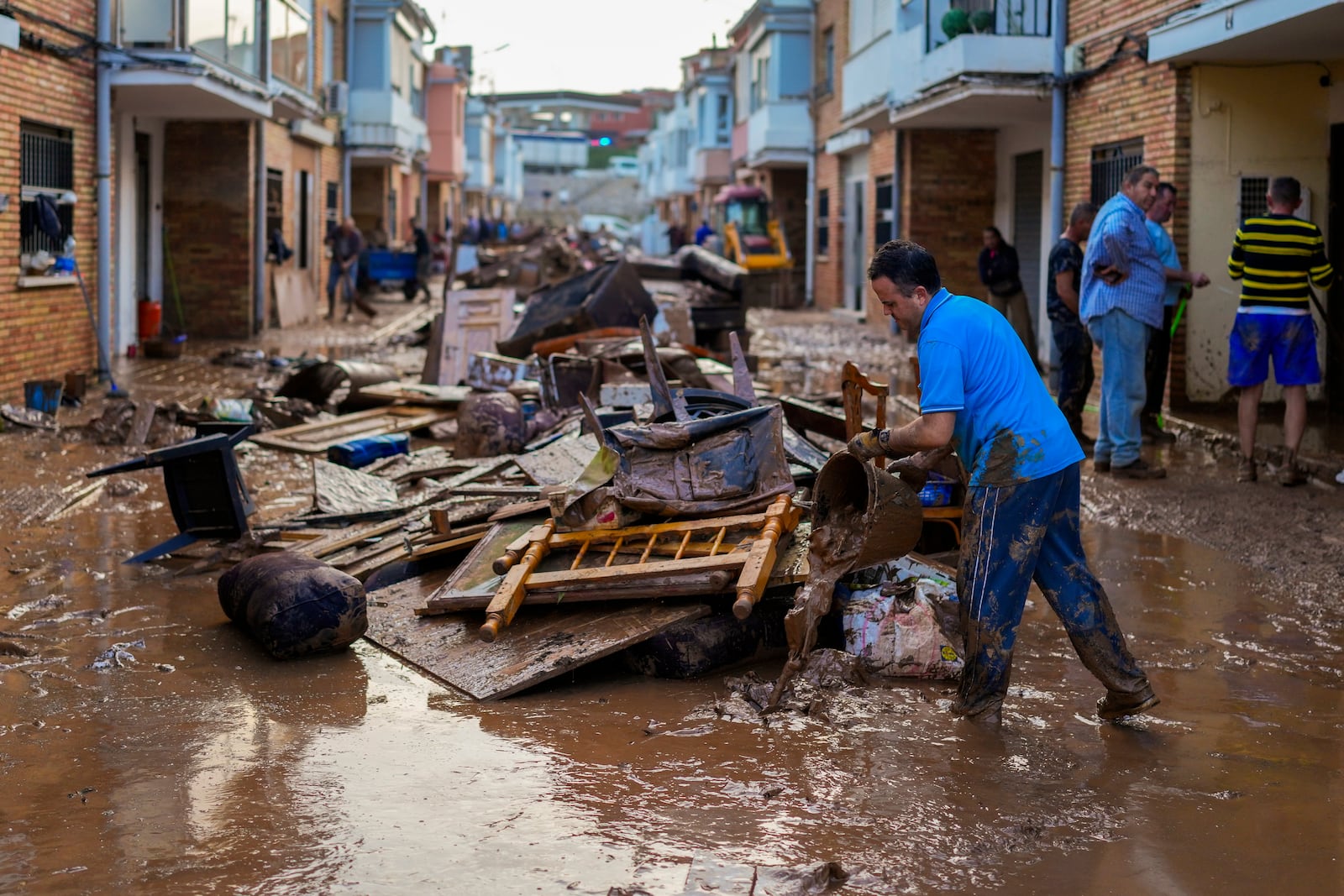 A man cleans his house affected by floods in Utiel, Spain, Wednesday, Oct. 30, 2024. (AP Photo/Manu Fernandez)