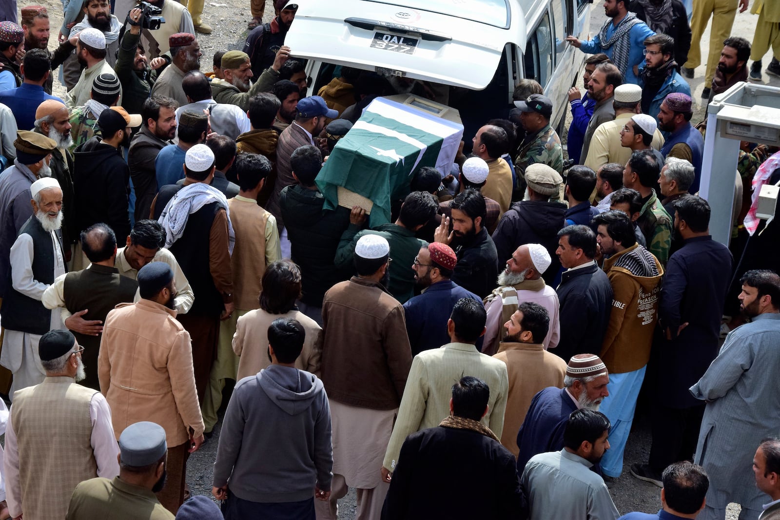 Mourners unload the casket of a victim of the train that was attacked by insurgents, for a funeral prayer in Quetta, Pakistan's southwestern Balochistan province, Thursday March 13, 2025. (AP Photo/Arshad Butt)