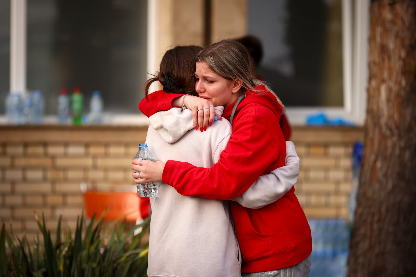 Women cry and hug outside a hospital in the town of Kocani, North Macedonia, Sunday, March 16, 2025, following a massive fire in the nightclub early Sunday. (AP Photo/Armin Durgut)