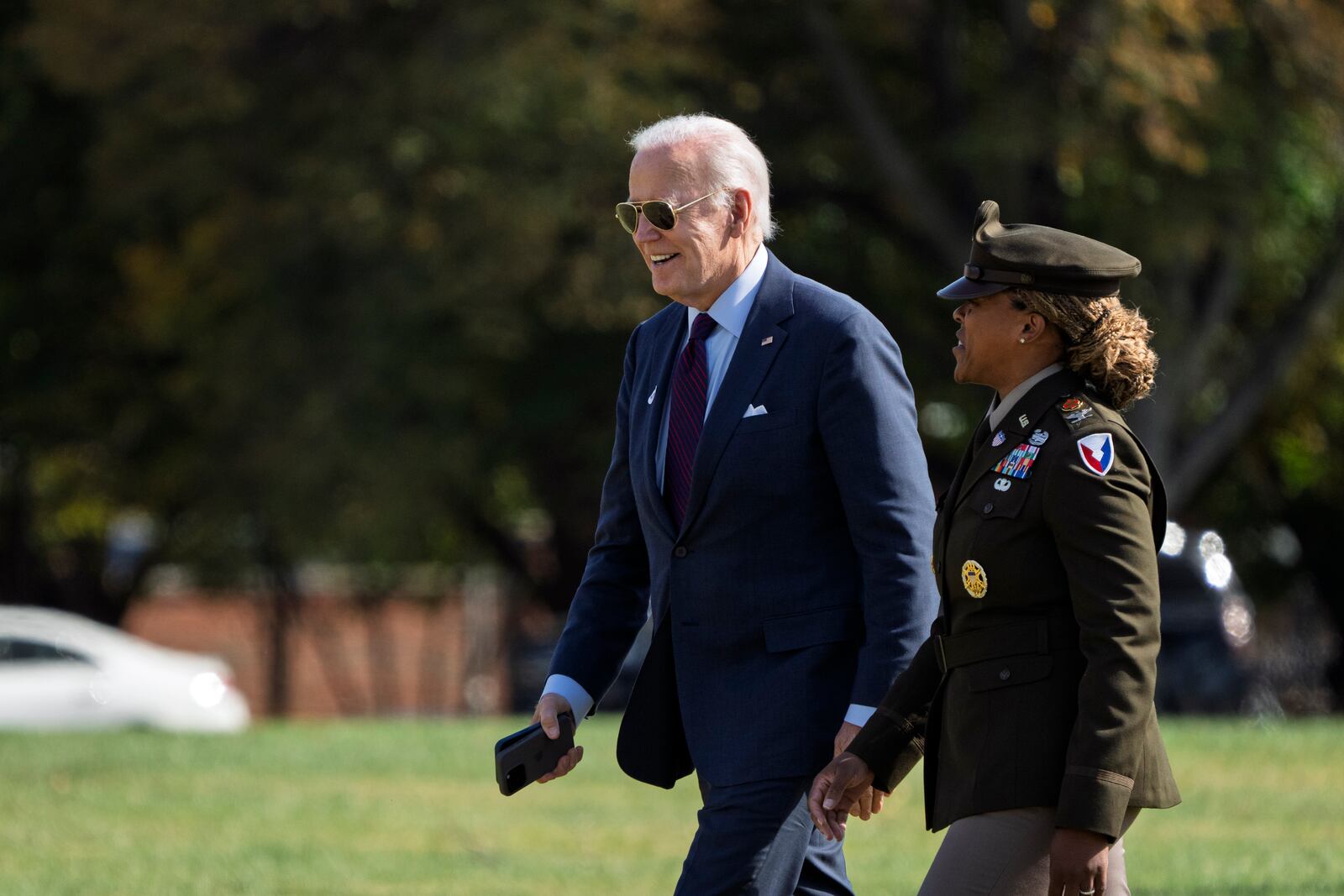 President Joe Biden, left, is escorted by Col. Tasha N. Lowery as he walks from Marine One after arriving at Fort McNair in Washington, Monday, Oct. 28, 2024. (AP Photo/Ben Curtis)