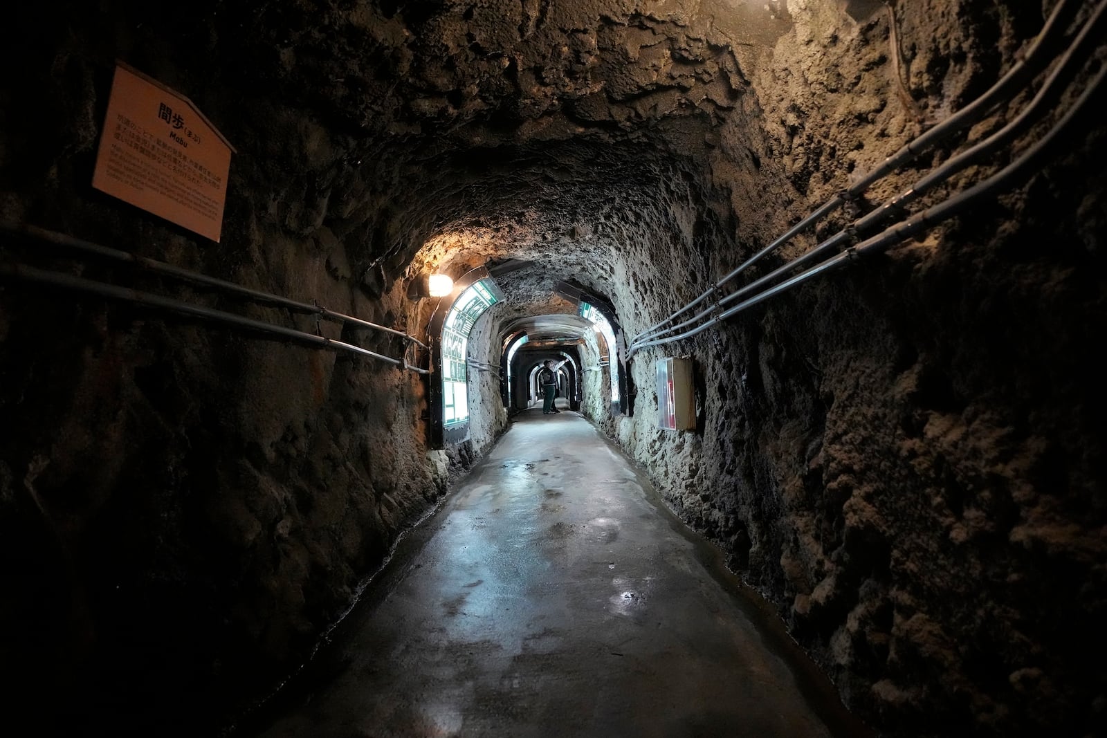 Visitors walk though a tunnel at Sado Kinzan Gold Mine historic site in Sado, Niigata prefecture, Japan, Saturday, Nov. 23, 2024. (AP Photo/Eugene Hoshiko)