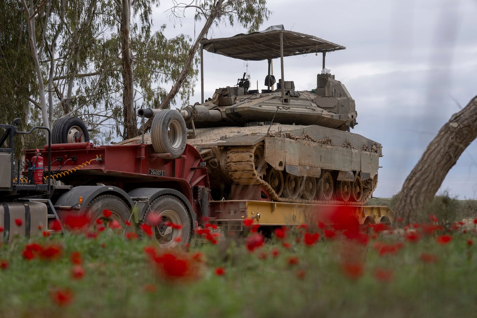 An Israeli tank is loaded onto a transport truck near the border with the Gaza Strip in southern Israel, Sunday, Feb. 9, 2025. (AP Photo/Ohad Zwigenberg)