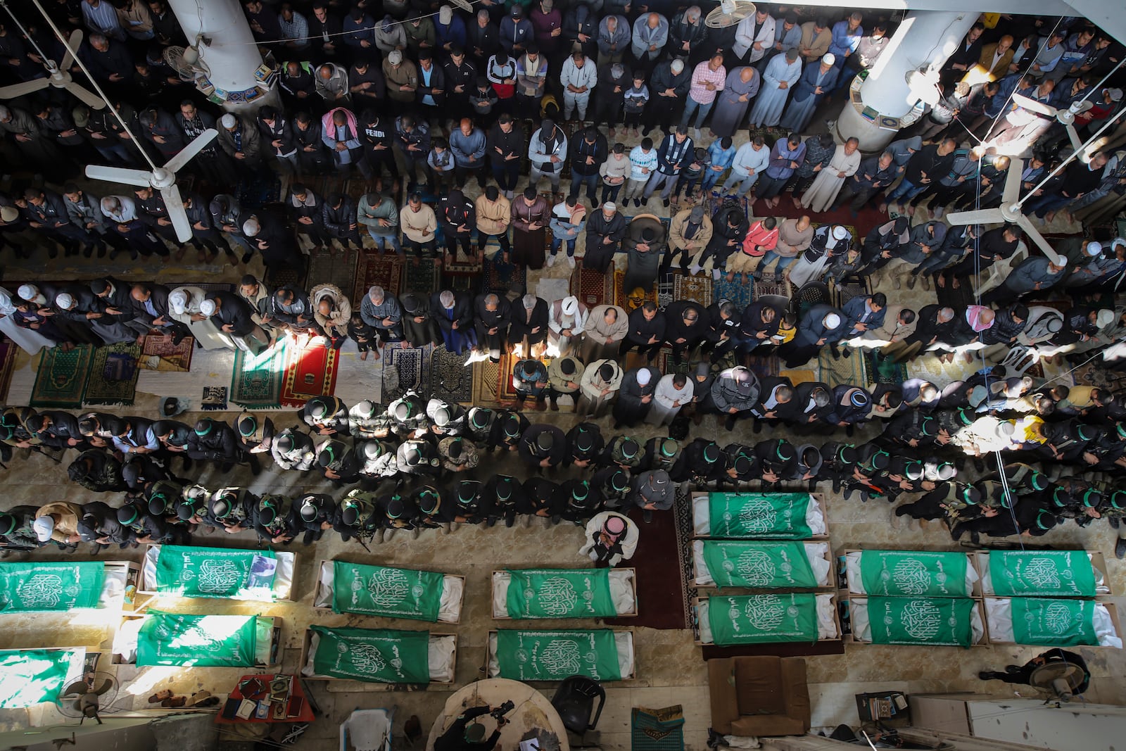 Palestinians pray by the bodies of fifteen members of the Izzedine al-Qassam Brigades, the military wing of Hamas movement, who were killed in Israeli bombardment of the Gaza Strip, in Khan Younis, Friday, Jan. 31, 2025. (AP Photo/Jehad Alshrafi)