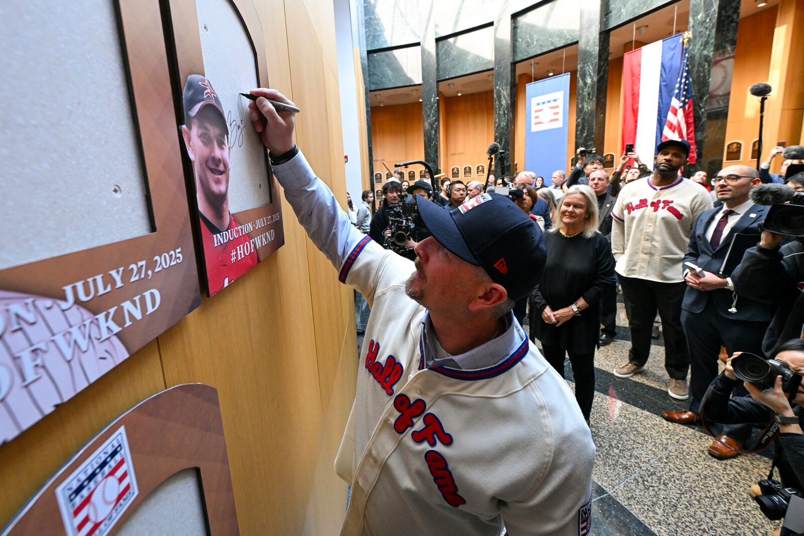 Newly-elected Baseball Hall of Fame member Billy Wagner signs the backer board where his plaque will hang during a news conference Thursday, Jan. 23, 2025, in Cooperstown, N.Y. (AP Photo/Hans Pennink)