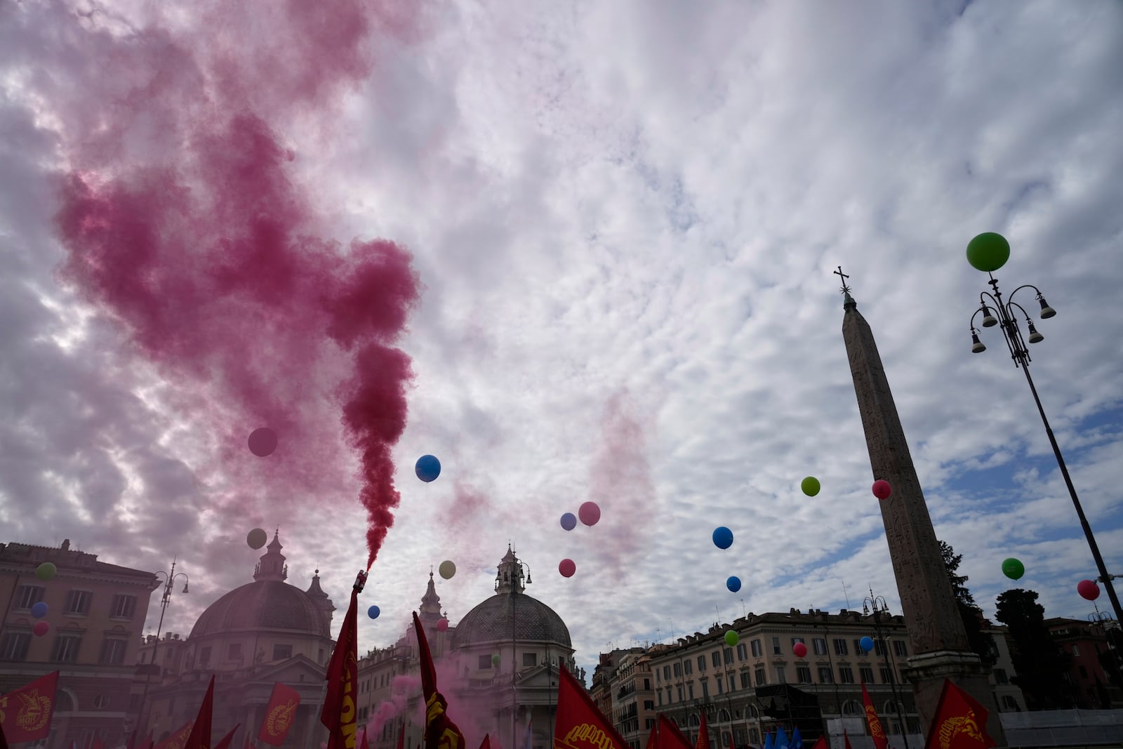 Workers of automotive sector burn flares in Rome's Piazza Del Popolo Square during a demonstration on the occasion of their national strike, Friday, Oct. 18, 2024. (AP Photo/Gregorio Borgia)