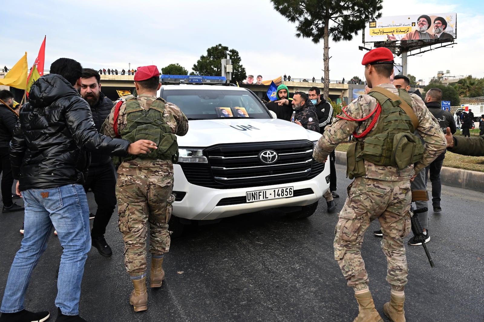 Lebanese army soldiers protect a convoy of the United Nations peacekeeping forces in Lebanon (UNIFIL), as Hezbollah supporters try to block the road that links to Beirut's international airport during a protest against Lebanon's decision to revoke permission for an Iranian carrier after Israel accused Iran of smuggling cash to Hezbollah, in Beirut, Lebanon, Saturday, Feb. 15, 2025. (AP Photo)