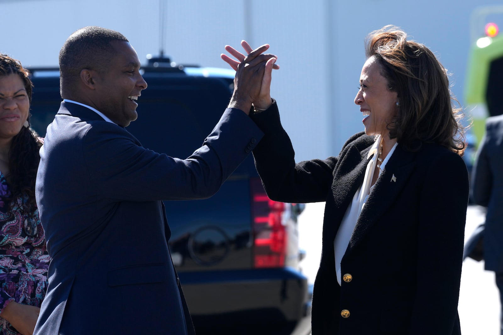 Democratic presidential nominee Vice President Kamala Harris, right, high-fives Rep. Don Davis, D-N.C., as she arrives at Pitt-Greenville Airport in Greenville, N.C., Sunday, Oct. 13, 2024, to speak at a campaign rally. (AP Photo/Susan Walsh)