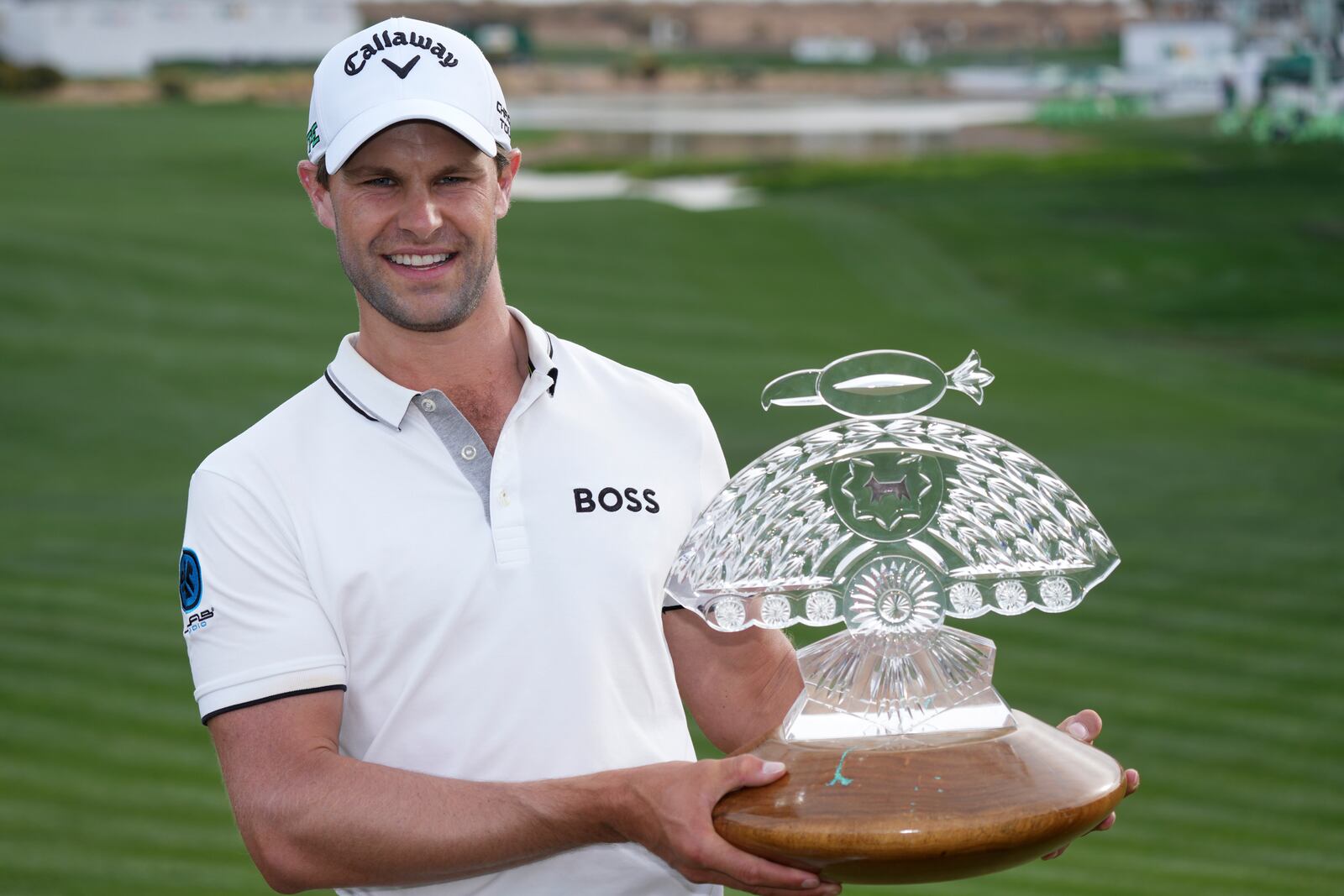 Thomas Detry, of Belgium, smiles as celebrates after his win at the Phoenix Open golf tournament at TPC Scottsdale while holding the winner's trophy and posing for photographers Sunday, Feb. 9, 2025, in Scottsdale, Ariz. (AP Photo/Ross D. Franklin)