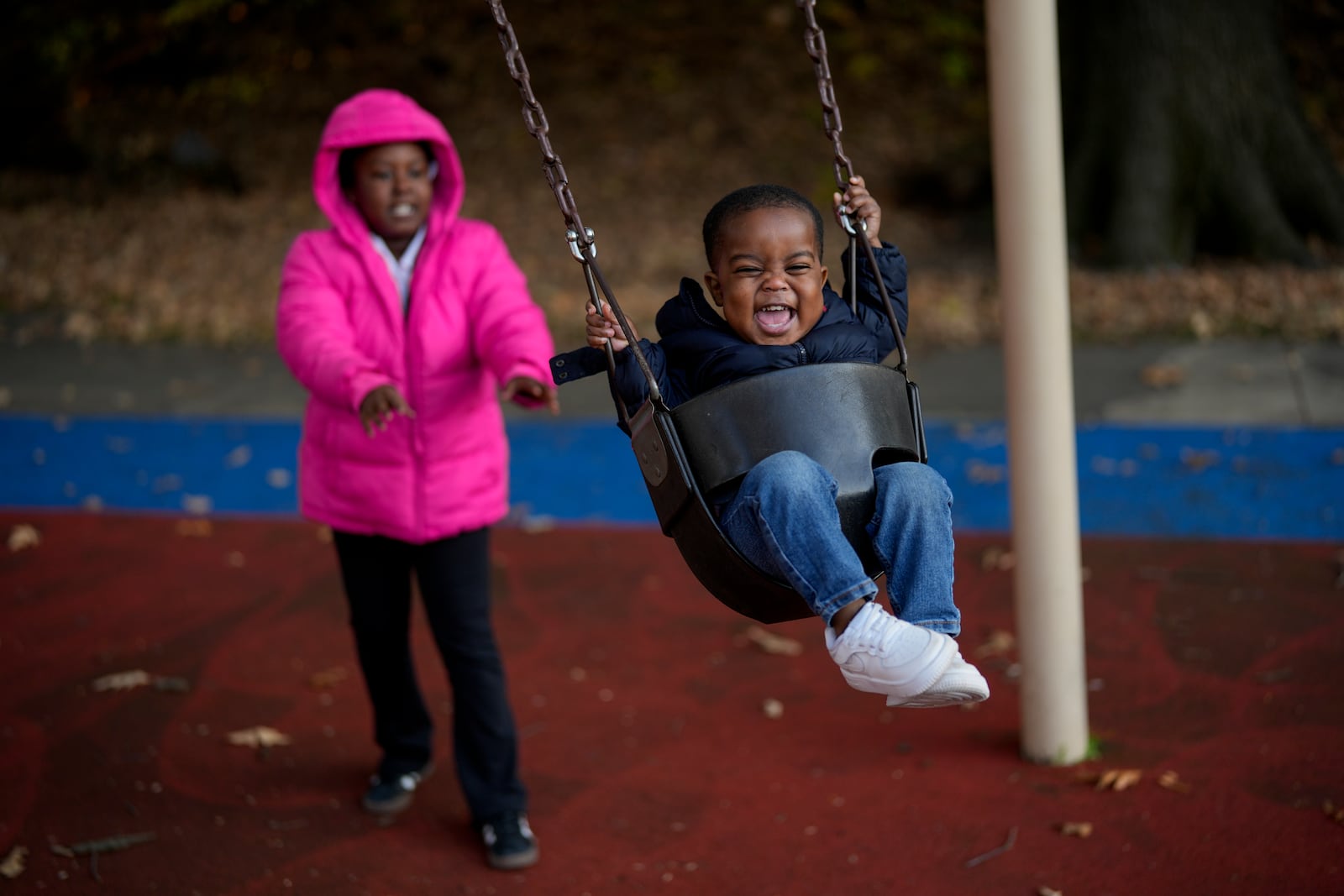 Makhi Chillis, 2, smiles as he is pushed in a swing by his sister Myla Chillis, 9, Monday, Dec. 2, 2024, in Memphis, Tenn. (AP Photo/George Walker IV)