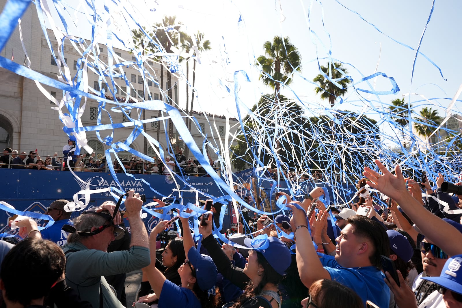 Fans cheer as buses carrying players are driven past during the Los Angeles Dodgers baseball World Series championship parade Friday, Nov. 1, 2024, in Los Angeles. (AP Photo/Jae C. Hong)