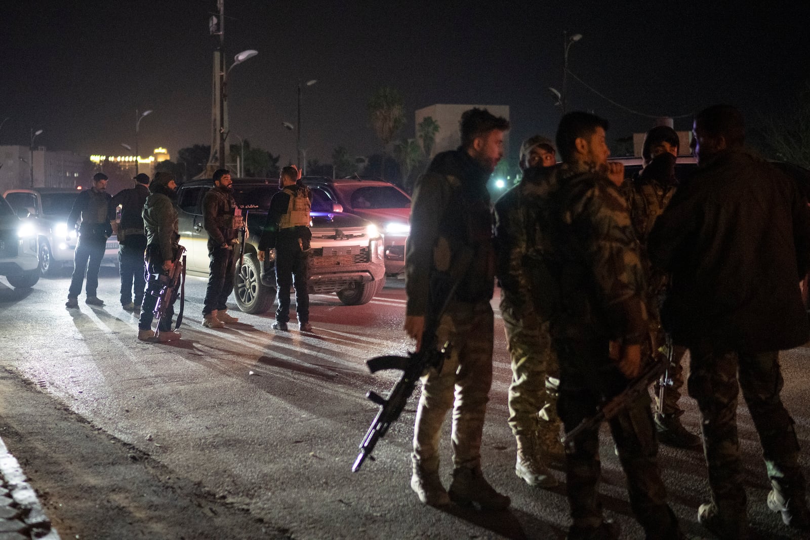 Syrian fighters gather during the night on a street in Damascus, Syria, Wednesday, Dec. 25, 2024. (AP Photo/Leo Correa)