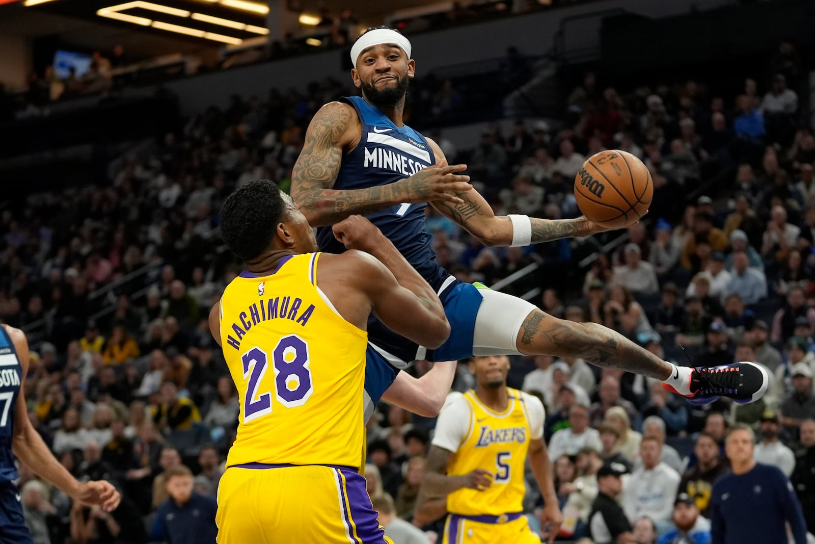 Minnesota Timberwolves guard Nickeil Alexander-Walker, top, looks to pass the ball as Los Angeles Lakers forward Rui Hachimura (28) defends during the first half of an NBA basketball game, Friday, Dec. 13, 2024, in Minneapolis. (AP Photo/Abbie Parr)