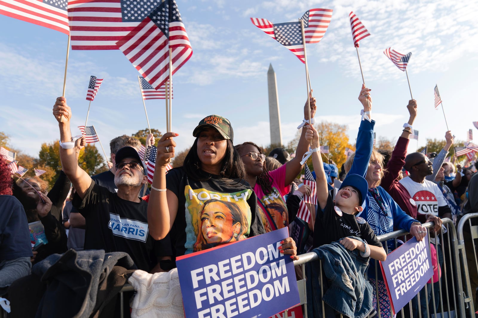 With the Washington Monument in the back ground supporters of Democratic presidential nominee Vice President Kamala Harris wave American flags as they attend a campaign rally in Washington, Tuesday, Oct. 29, 2024. (AP Photo/Jose Luis Magana)