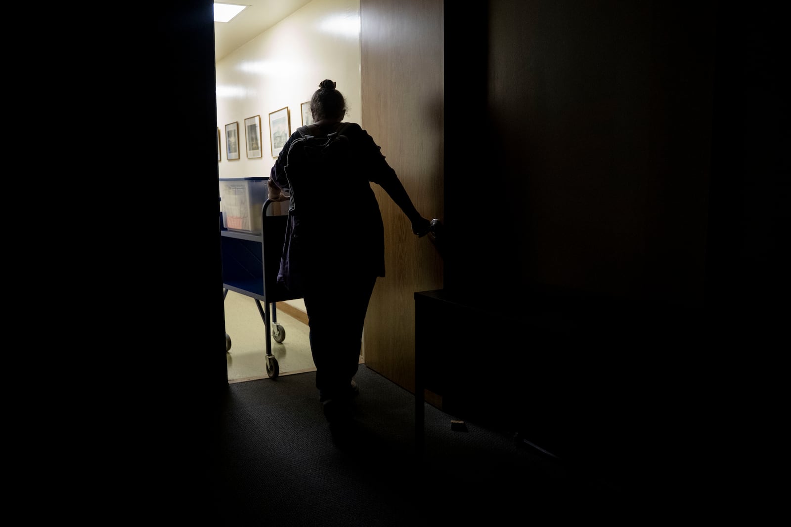 Pam Walton leaves a library with her container including photographs and lists of "Two by Twos" conventions, members and ministers, Monday, Dec. 9, 2024, in Wailea, Hawaii. (AP Photo/Mengshin Lin)