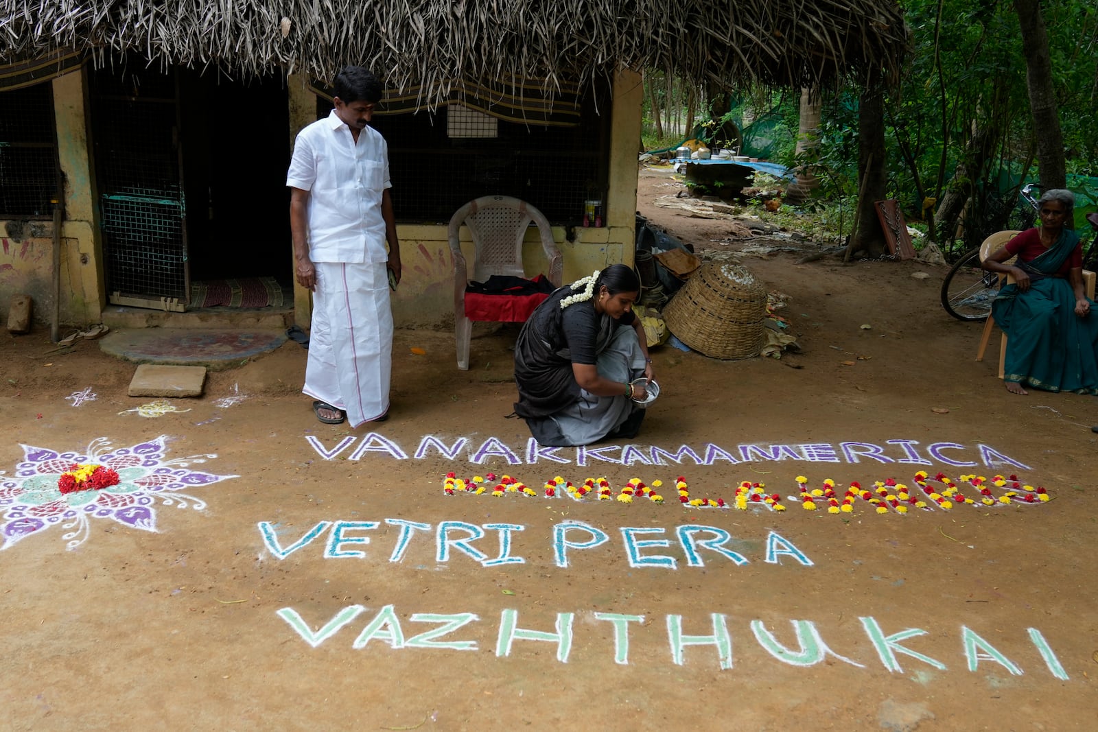 Local politician Arulmozhi Sudhakar prepares a Kolam, a traditional art work using colored powder, that reads "Greeting America, our wishes for Kamala Harris' victory" for Democratic presidential nominee Vice President Kamala Harris, in Thulasendrapuram, the ancestral village of Harris, in Tamil Nadu state, India, Tuesday, Nov. 5, 2024. (AP Photo/Aijaz Rahi)