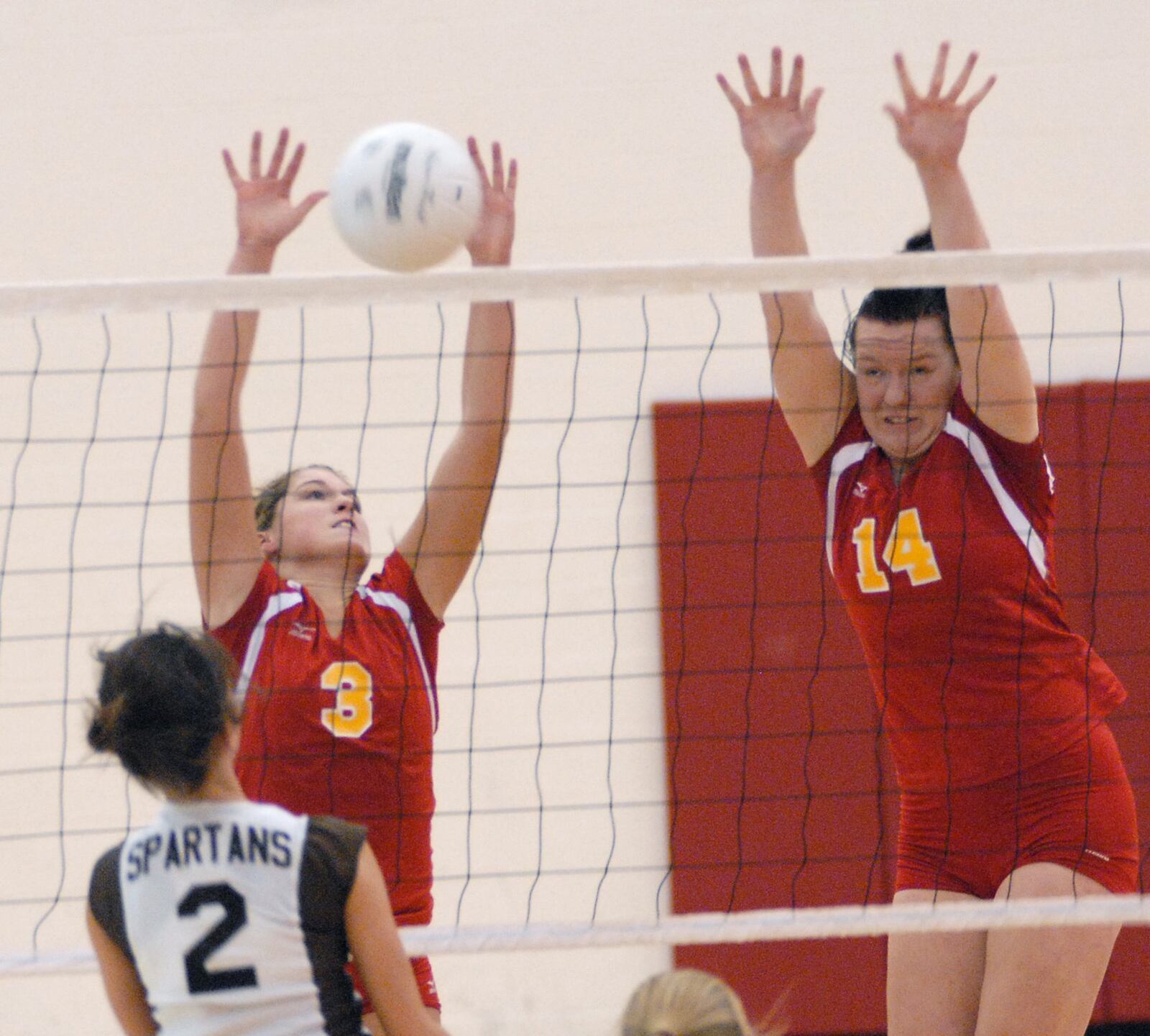 Fenwick’s Caitlin Thomas (14) and Lindsay Garriga (3) work against Roger Bacon’s Chelsea Sprong (2) at the net on Oct. 27, 2007, during a Division III district final. JOURNAL-NEWS FILE PHOTO