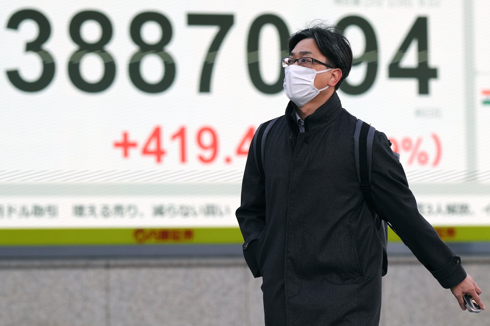 A person walks in front of an electronic stock board showing Japan's Nikkei index at a securities firm Monday, Jan. 20, 2025, in Tokyo. (AP Photo/Eugene Hoshiko)